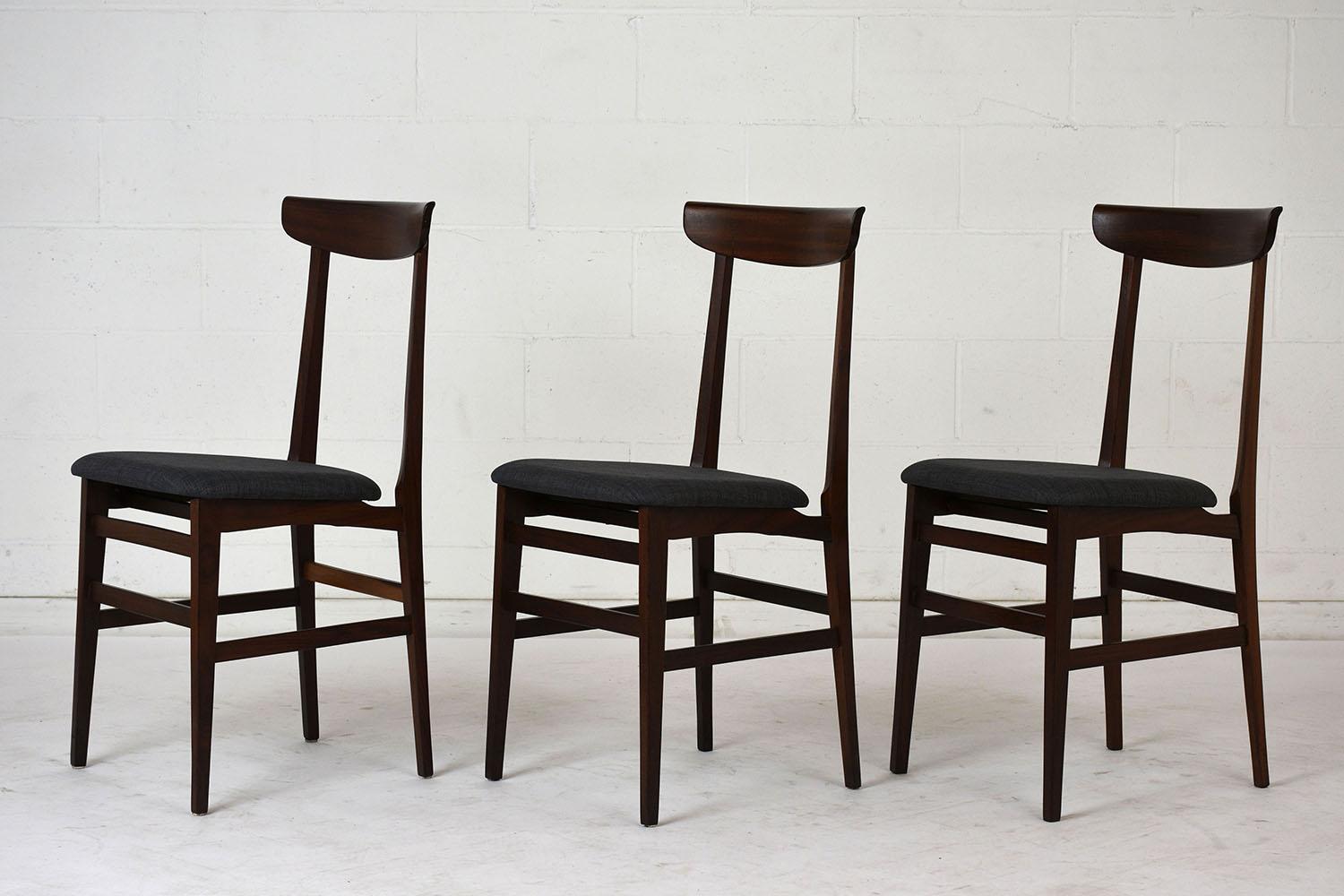This set of six 1960s Danish Mid-Century Modern-style dining chairs feature a carved rosewood frame stained in a rich rosewood color with a polished finish. The chairs have a simple seat back with a curved top rail. The chairs are finished with