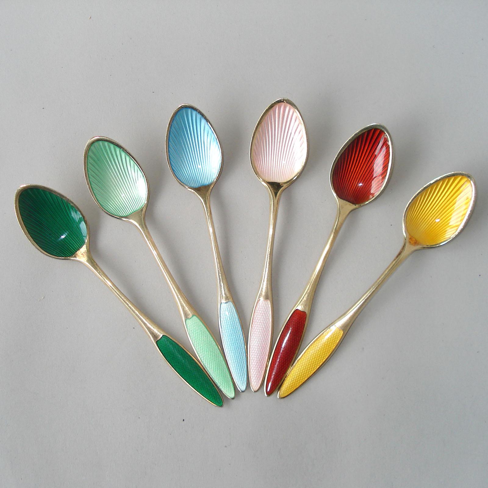Set of six Danish spoons in gilt sterling silver with polychrome enamel in green, light green, light blue, pink, yellow, and red, circa 1930. Each hallmarked 