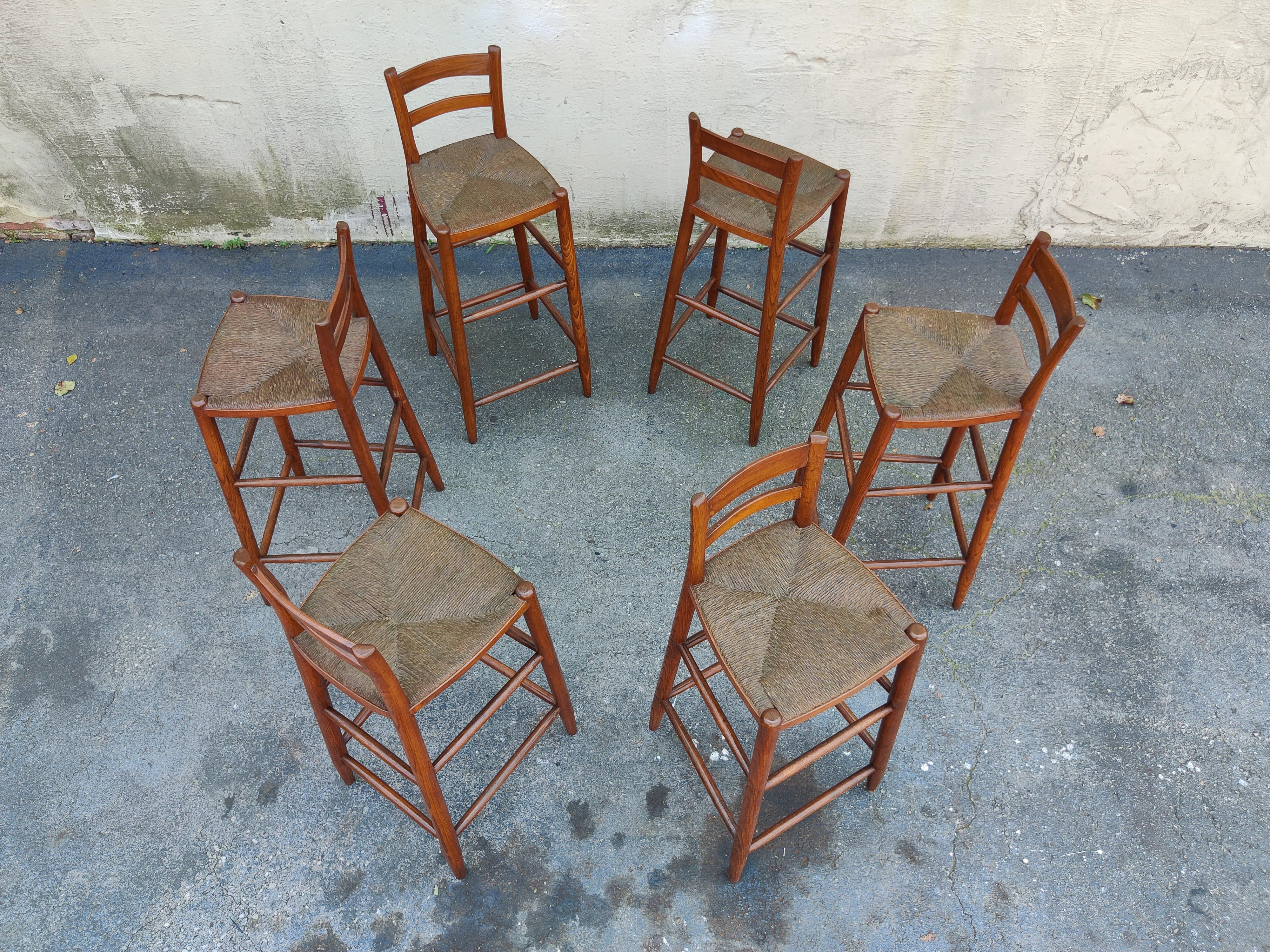 This handsome set of stools were made in the 1970s after the surge in popularity of Danish designers like Hans J. Wegner. Made with oak frames, teak slats, and a comfortable woven rush seat, this set was designed in the style of these sought-after