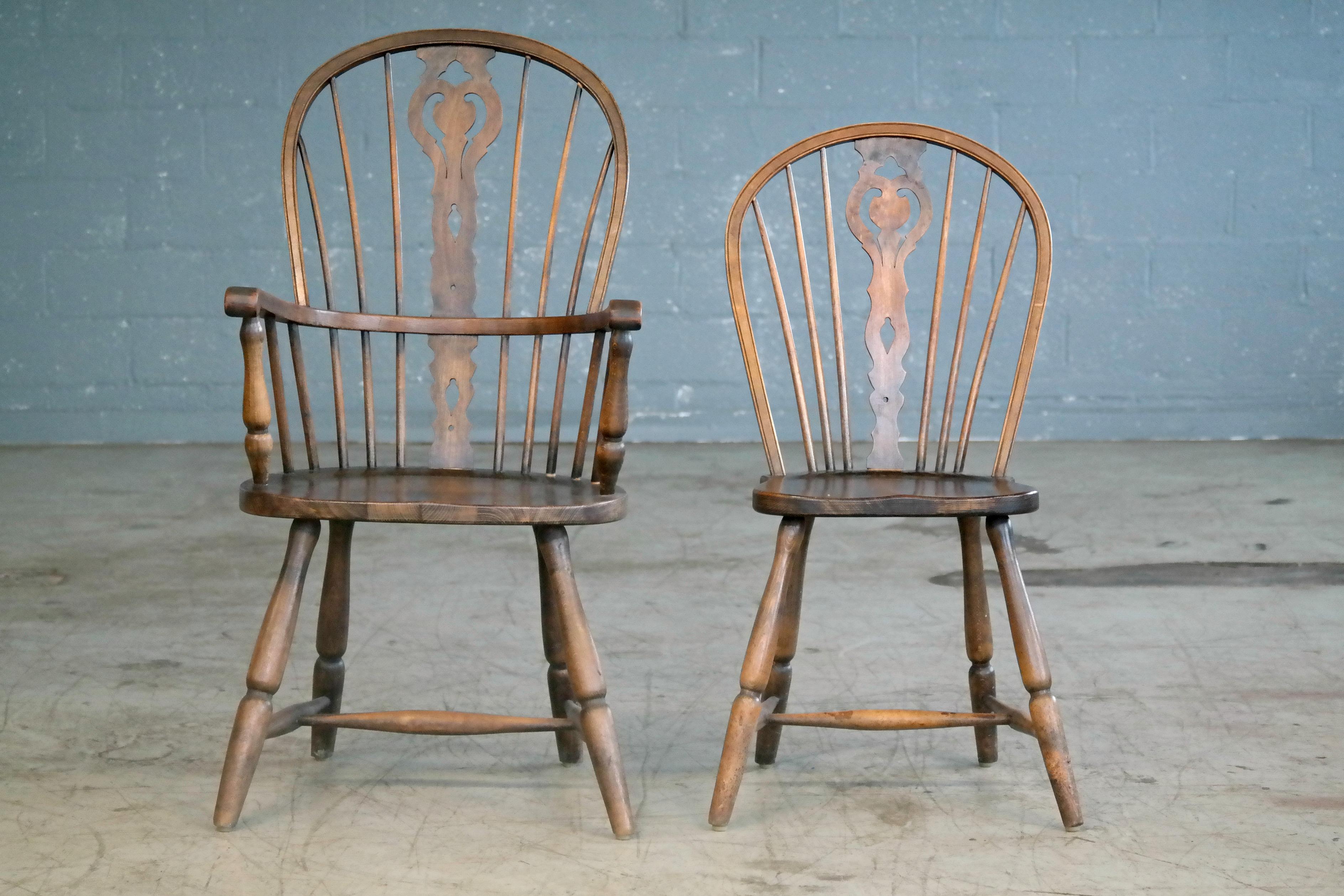 Great set of six Danish dining or kitchen chairs in traditional Windsor style with splat backs and saddle-style seating. Two captain's chairs with armrests and four side chairs. Made from dark stained beech wood sometime between 1930 and 1950 in