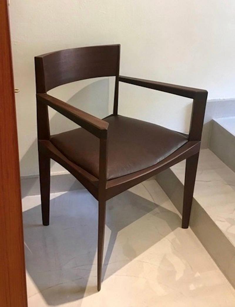 Set of six Italian modern dining chairs. Sleek design with elegantly shaped narrow legs. Solid dark stained wood and chocolate brown faux leather seat covers. Recently restored.