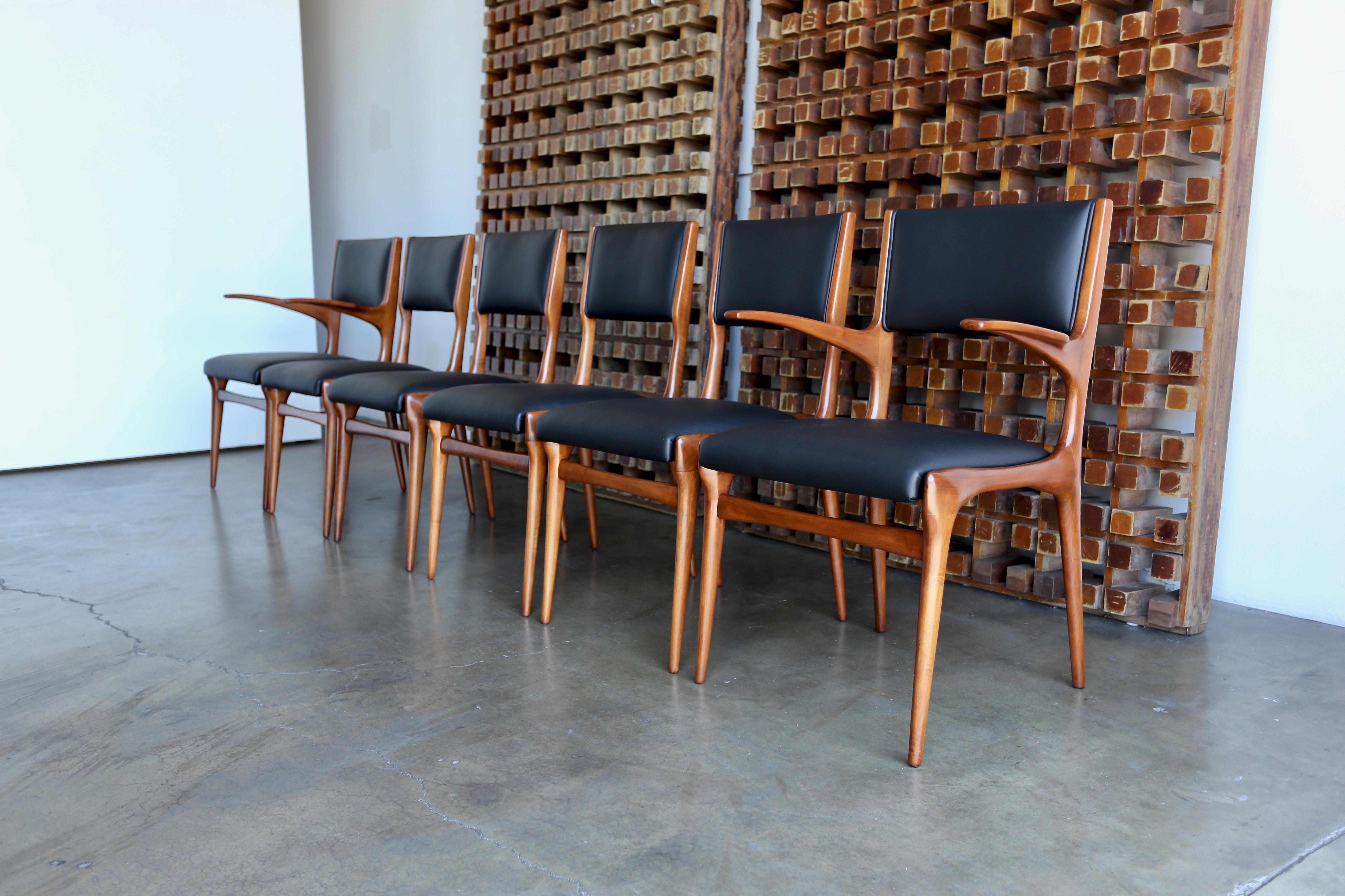 Set of six Carlo di Carli dining chairs. Manufactured by Cassina, circa 1953. This set has been professionally restored. 

Two arms and four sides. 

Each armchairs measures: 22