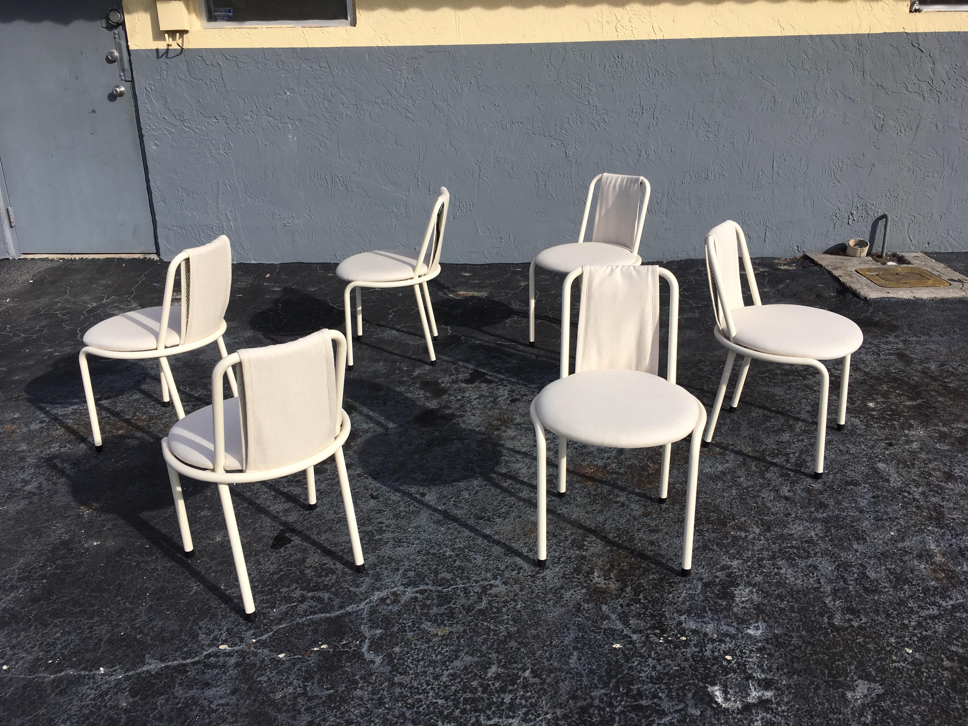 Six chaises de salle à manger signées Giovannetti, structure tubulaire avec une finition blanc antique. La tapisserie est neuve, de couleur blanc cassé oatmeal. Les chaises peuvent paraître jaunes sur les photos en raison de la lumière du soleil. De