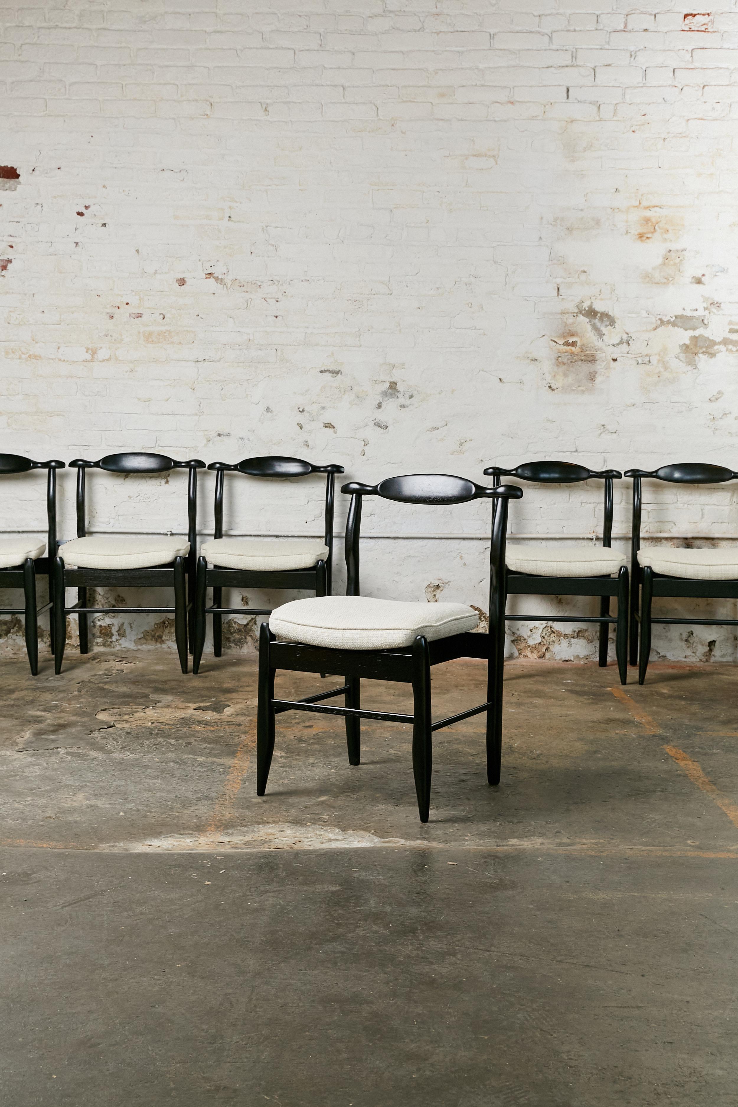Set of six dining chairs designed by Guillerme et Chambron. Made of oak and re-stained in black. Seat re-upholstered in off white thick weave fabric.