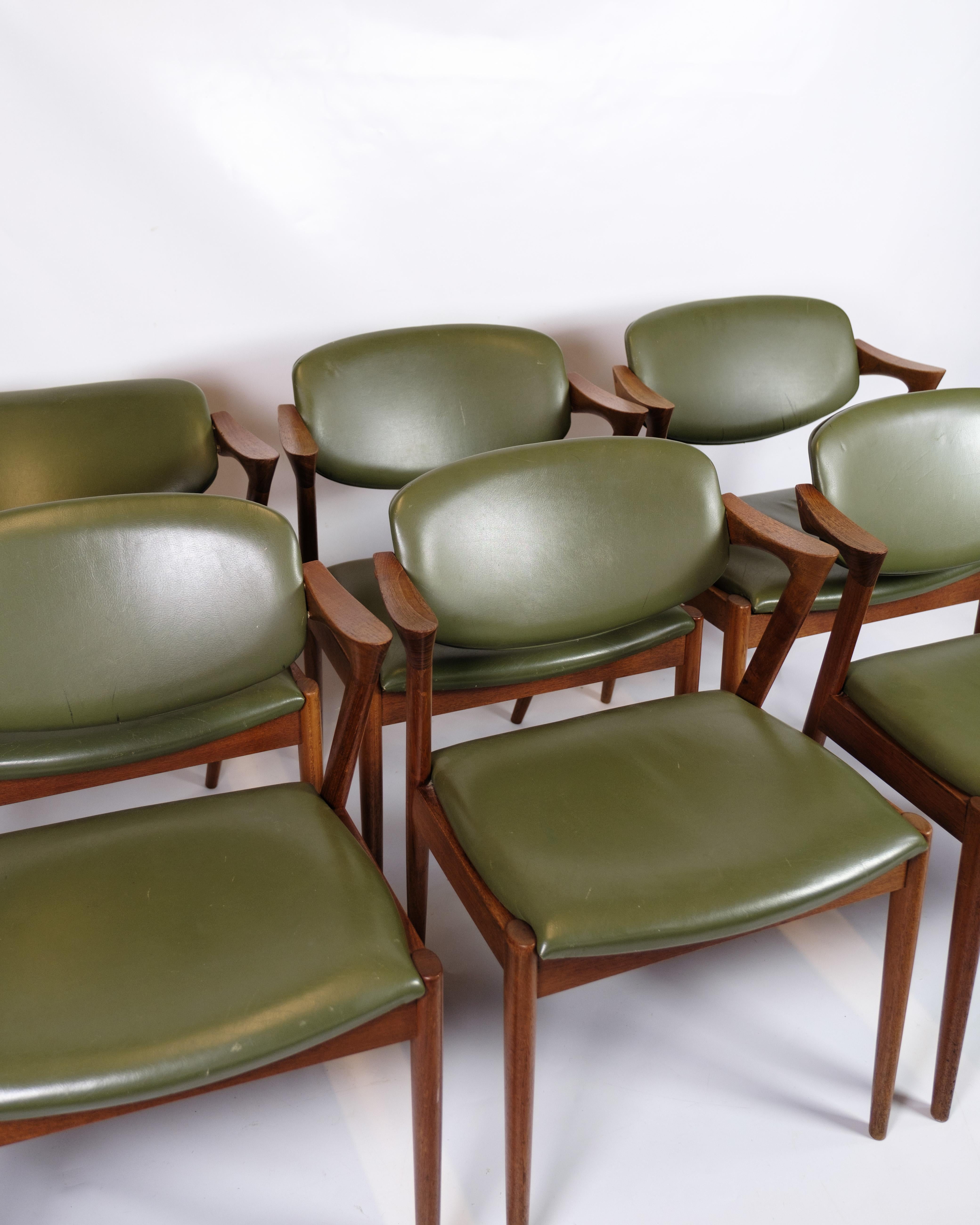 Set di 6 sedie da pranzo, modello 42, disegnate da Kai Kristiansen e prodotte da Schou Andersen negli anni Sessanta. Le sedie sono realizzate in teak, che conferisce loro un aspetto caldo e naturale, e sono rivestite in pelle verde. Il modello 42 è
