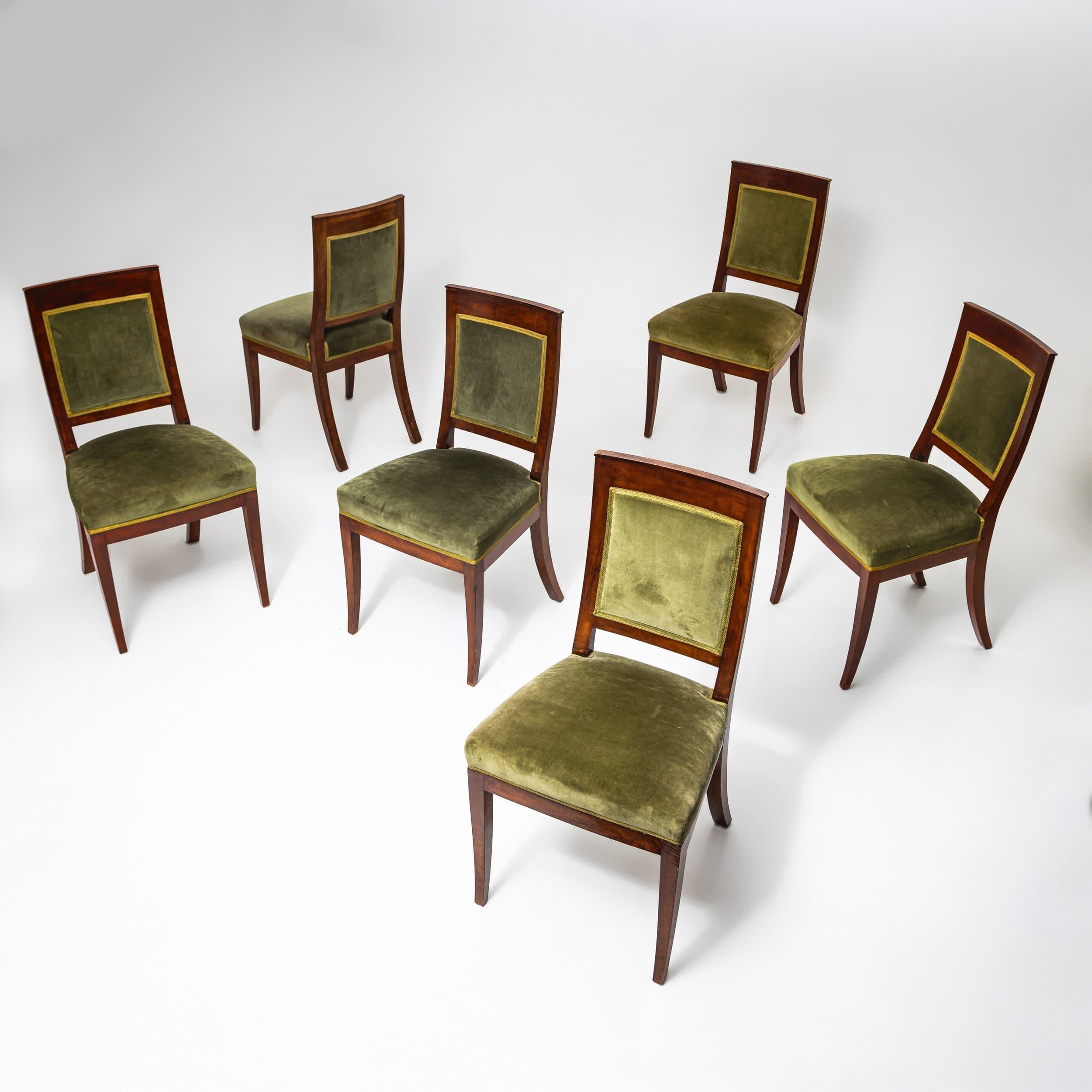 Set of six 19th-century dining chairs featuring rectangular upholstered backrests and trapezoidal seats. The chairs stand on slightly splayed, tapered legs, enhancing their elegant silhouette.
Upholstered in green velvet, they exude a refined,