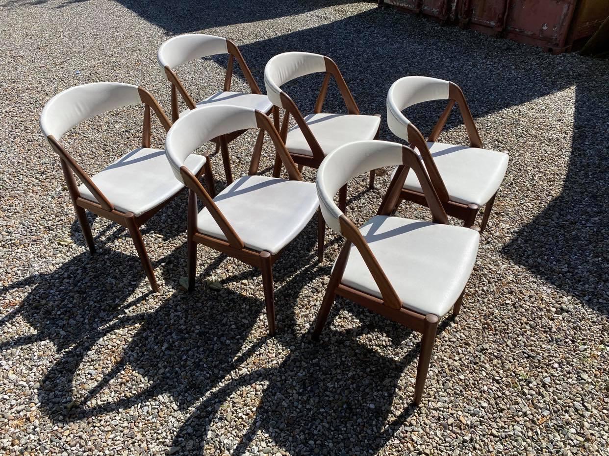 A set of six dining room chairs, model 31, designed by Kai Kristiansen in 1956 and manufactured by Schou Andersen in the 1960s. The chairs are of teak and upholstered in light grey Hallindal wool fabric. The chairs has been purchased the full