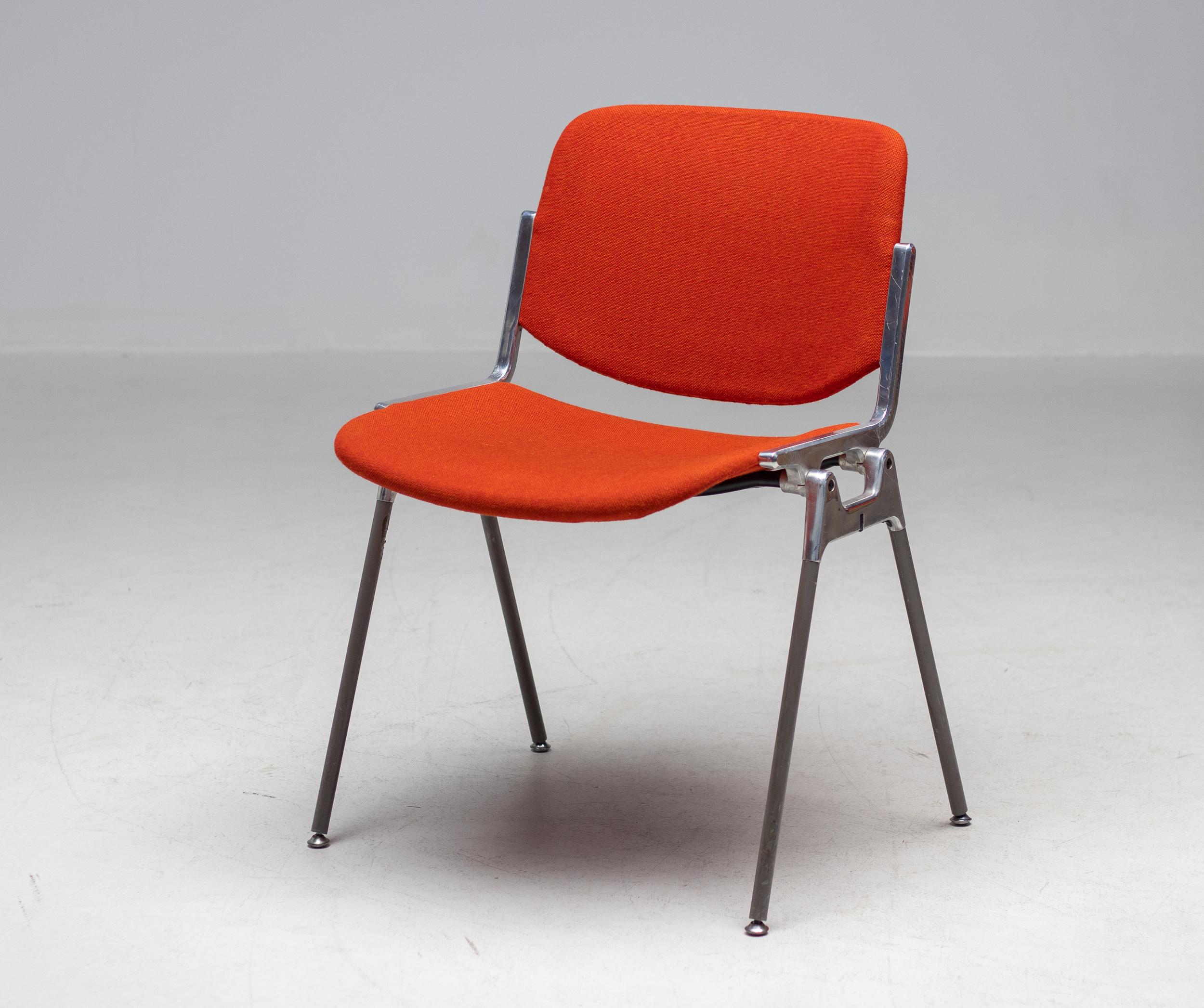 A set of six bright orange/red Giancarlo Piretti DSC 106 chairs.
Form and function joined in the design of these renown stacking chairs by Giancarlo Piretti for Anonima Castelli. Upholstered beech plywood seat and back on a sturdy molded aluminum