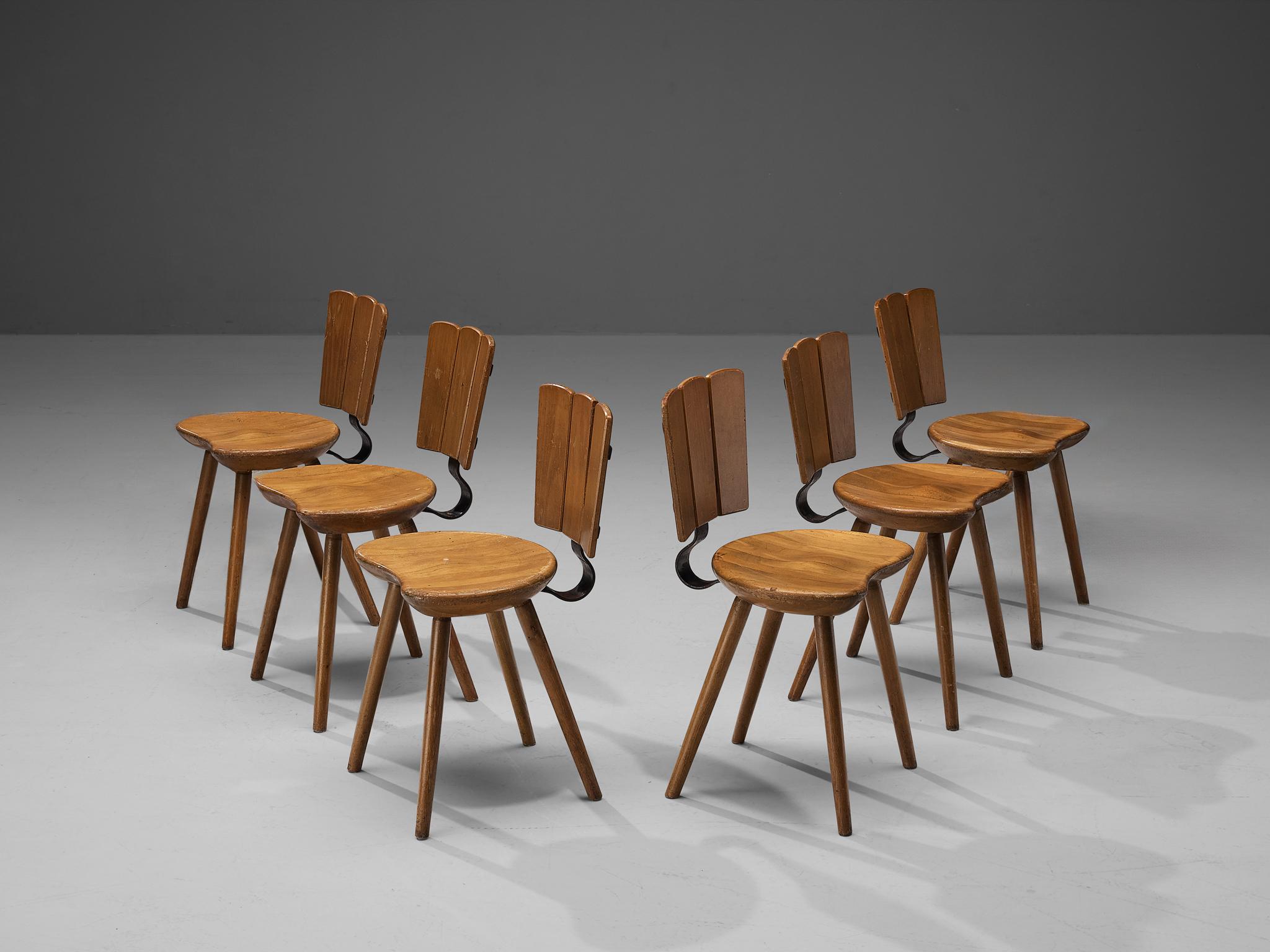 Dining chairs, stained beech, cast iron, The Netherlands, 1970s. 

Rustic set of six Dutch dining chairs made in the 1970s. This design in stained beech features a curved cast iron backrest support. Despite the sturdy look of the design, these