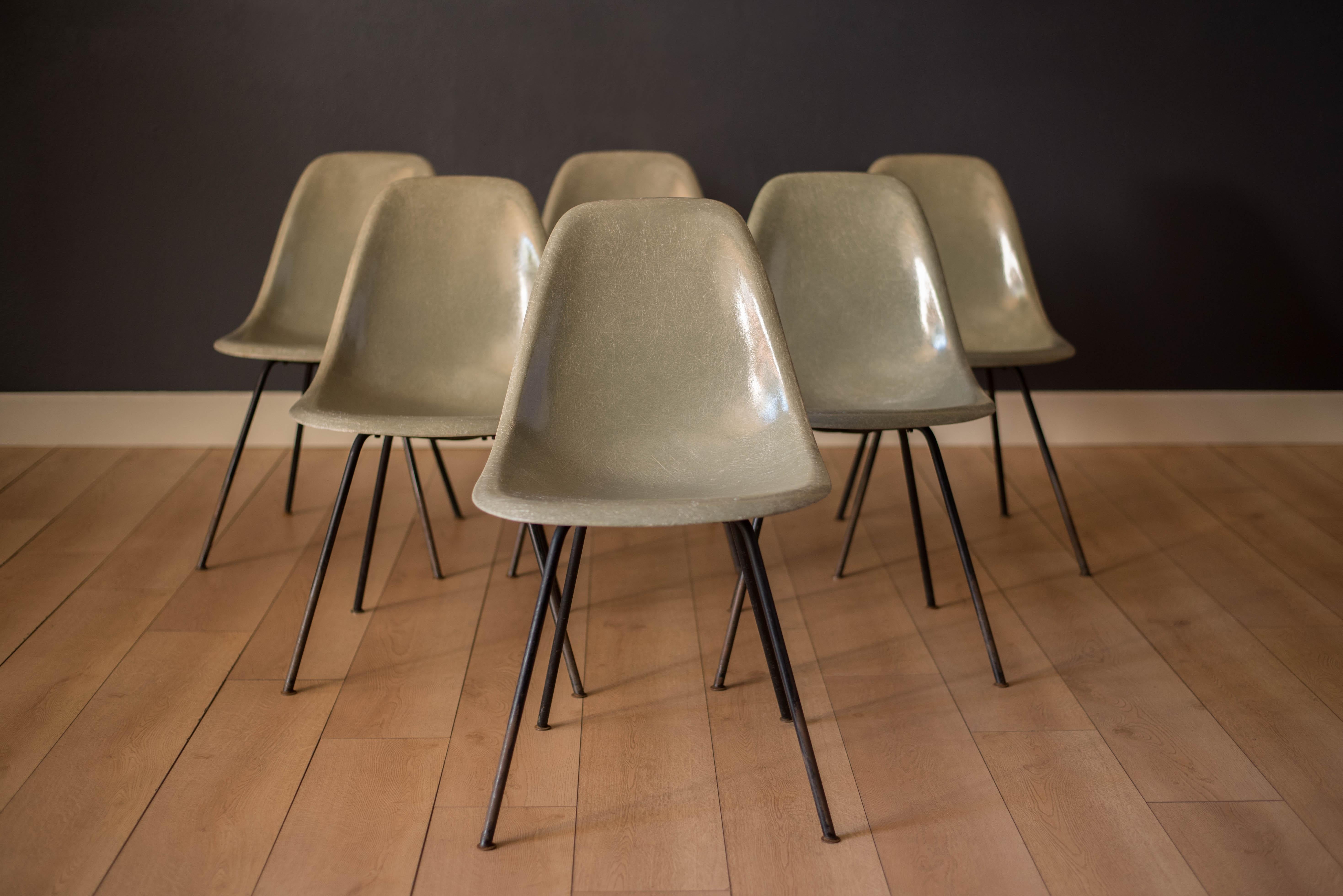 Mid-Century Modern first generation DSX side chairs by Ray and Charles Eames for Herman Miller circa 1950s. This collectible set features seafoam green fiberglass colored shells supported by the original heavy black steel framed X-base. Price is for