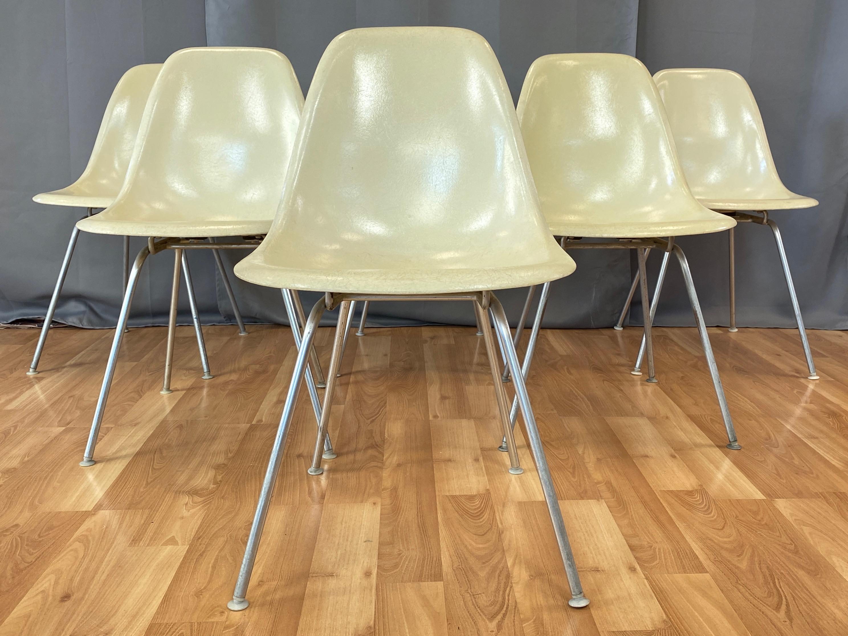A set of six circa 1959 parchment color fiberglass side chairs with original bases by Charles and Ray Eames for Herman Miller.

Five chairs are DSX on narrow mount ‘H’ bases, and one chair is DSG (Dining Side Guard) on narrow mount ‘H’ base with