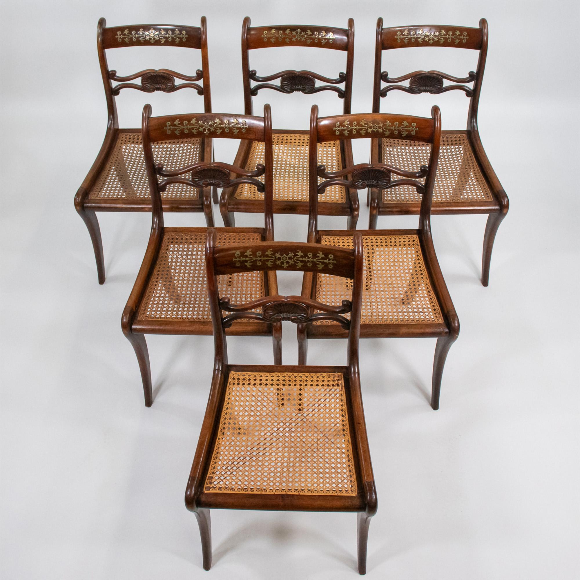 Questo eccezionale set di sedie Regency, risalente al 1810 circa, incarna l'eleganza e la maestria dell'epoca. Sapientemente lavorata in faggio per assomigliare al palissandro, ogni sedia è caratterizzata da gambe a sciabola (saber) splendidamente
