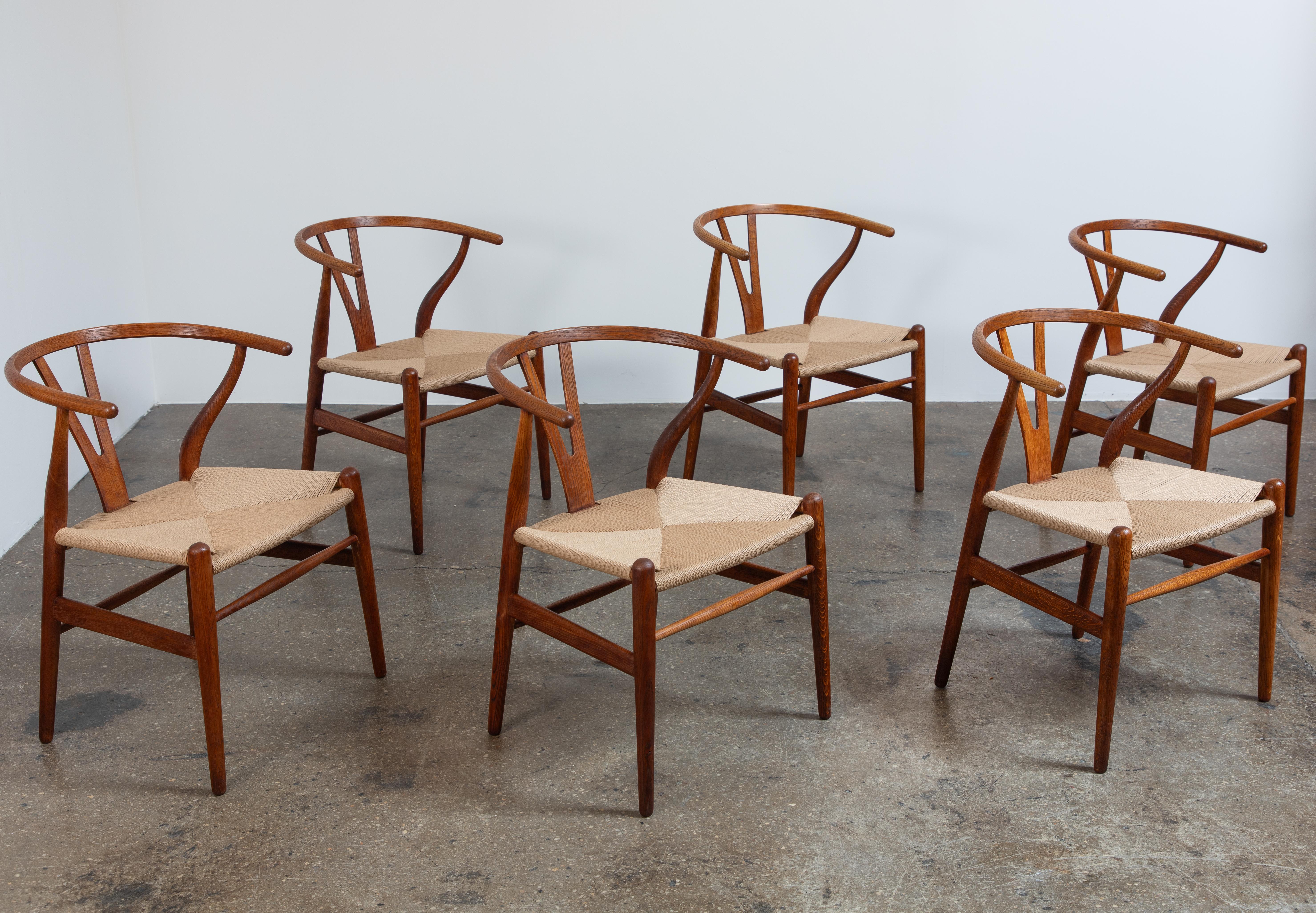 Set of six model CH-24 dining chairs, designed by Hans J. Wegner for Carl Hansen & Son. These iconic dining chairs combine seasoned elegance with fine craft.  Robust oak wood frame has aged nicely, with the wishbone “Y” backing and rounded armrests