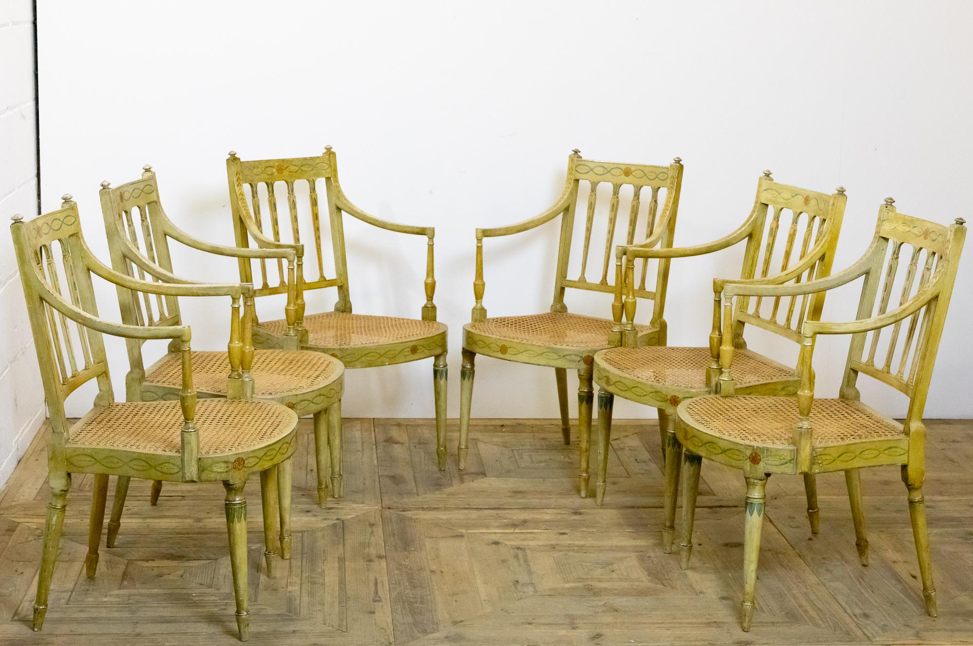 A truly stunning set of six painted armchairs, dating to the early 20th century. In the George III style with caned seats. All in their original paint and retaining much of their decoration aged with a lovely patina and mellow color.