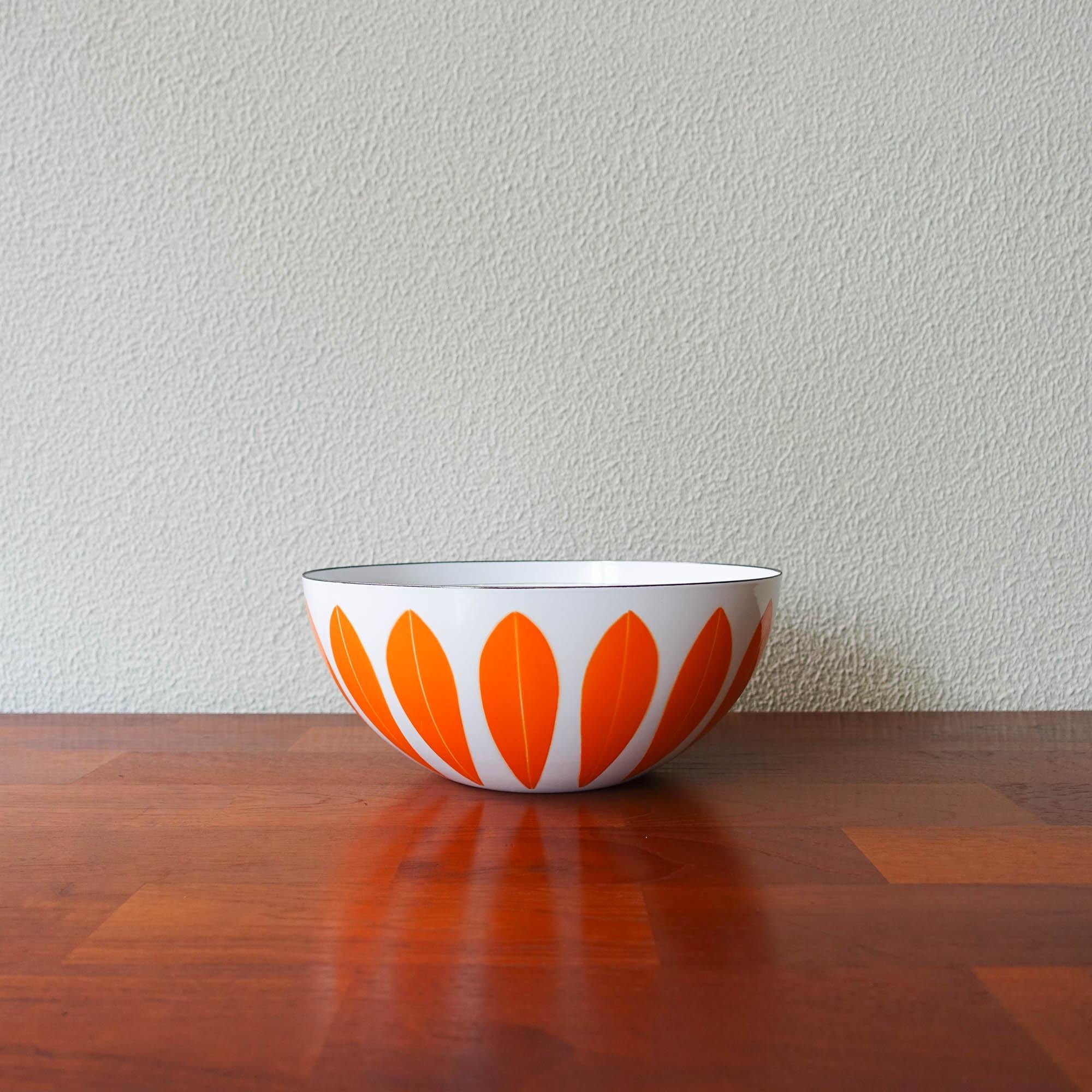 This set of bowls, model Lotus, was designed by Grete Prytz Kittelsen for Cathrineholm, in Norway, during the 1960's. This specific design was produced between 1962-1965. It is a complete set made of enamel metal in white with orange lotus leaves