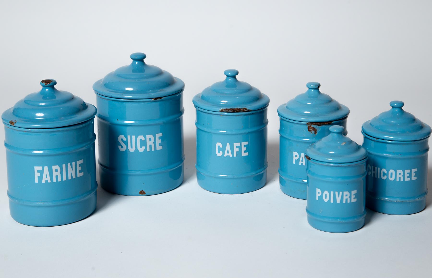 Juego de seis botes de esmalte, Bélgica, 1920. Un juego graduado de botes de almacenaje de cocina en un bonito color azul aciano con letras blancas en bloque. El más alto mide 7,25 pulgadas de alto; el más bajo mide 4,88 pulgadas de alto.