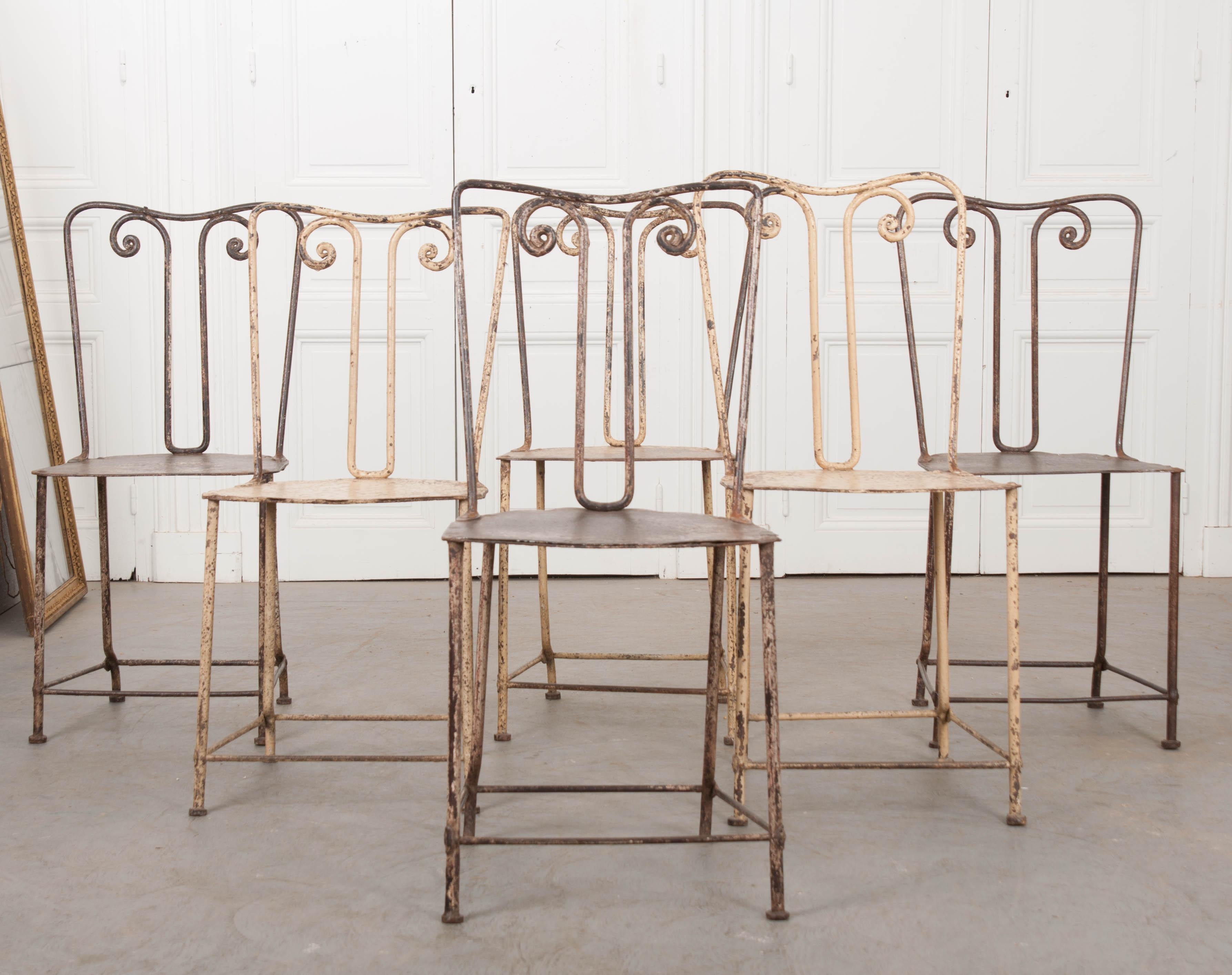 This charming set of six scroll-back wrought iron painted side chairs, circa 1880s, are from England. Retaining remnants of the original paint, these chairs have developed a wonderful patina over the last 140 years!