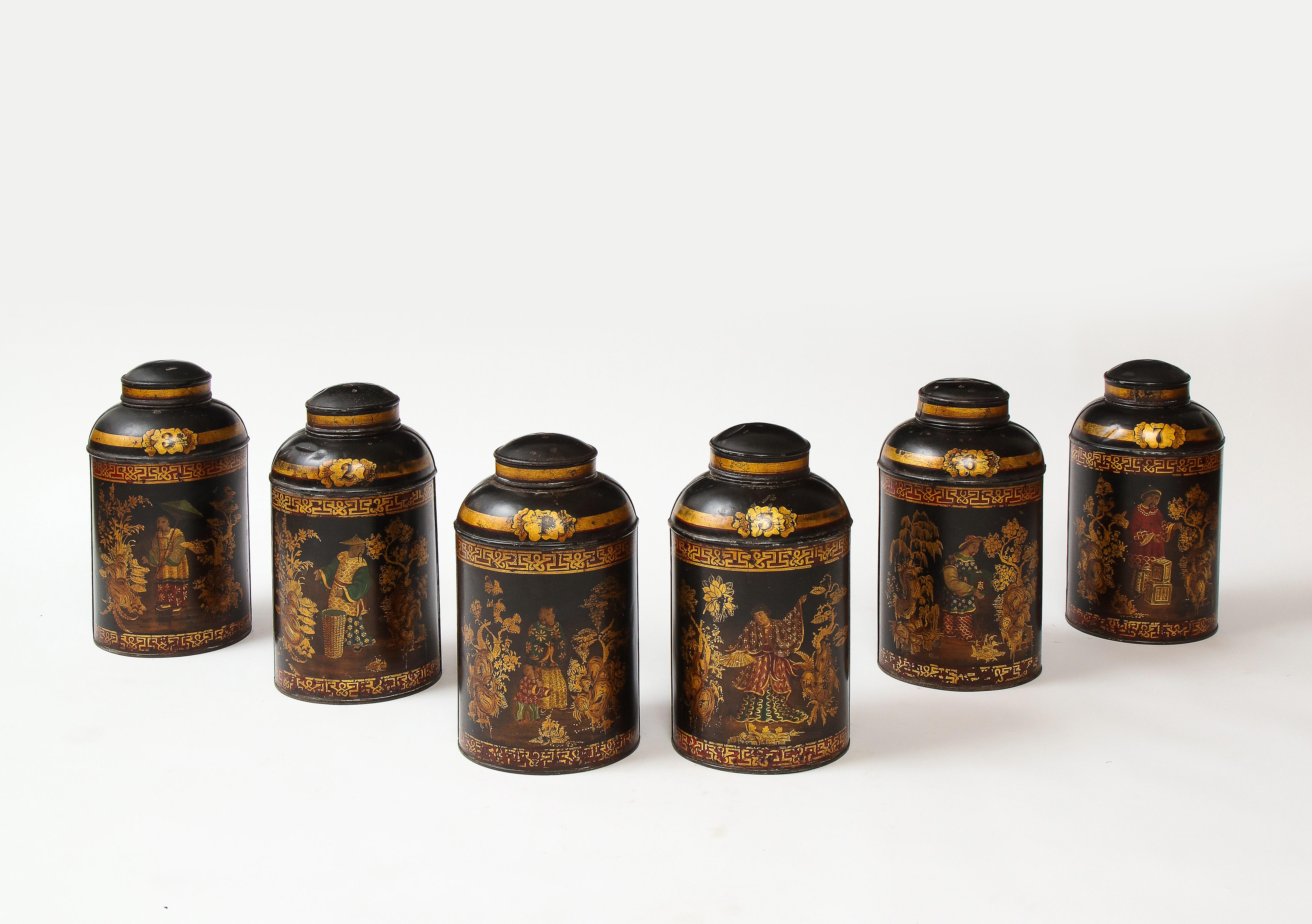 Each of cylindrical form with domed lid, elaborately decorated in vibrant polychrome with Mandarin figures in brightly-colored dress in exotic landscape settings, set between broad gilt fretwork banding; bearing cartouche inscribed with letters and