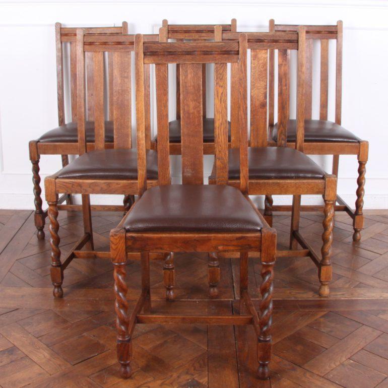A Classic set of six English solid-oak dining chairs, with barley twist legs and drop-in leather seats. 




 