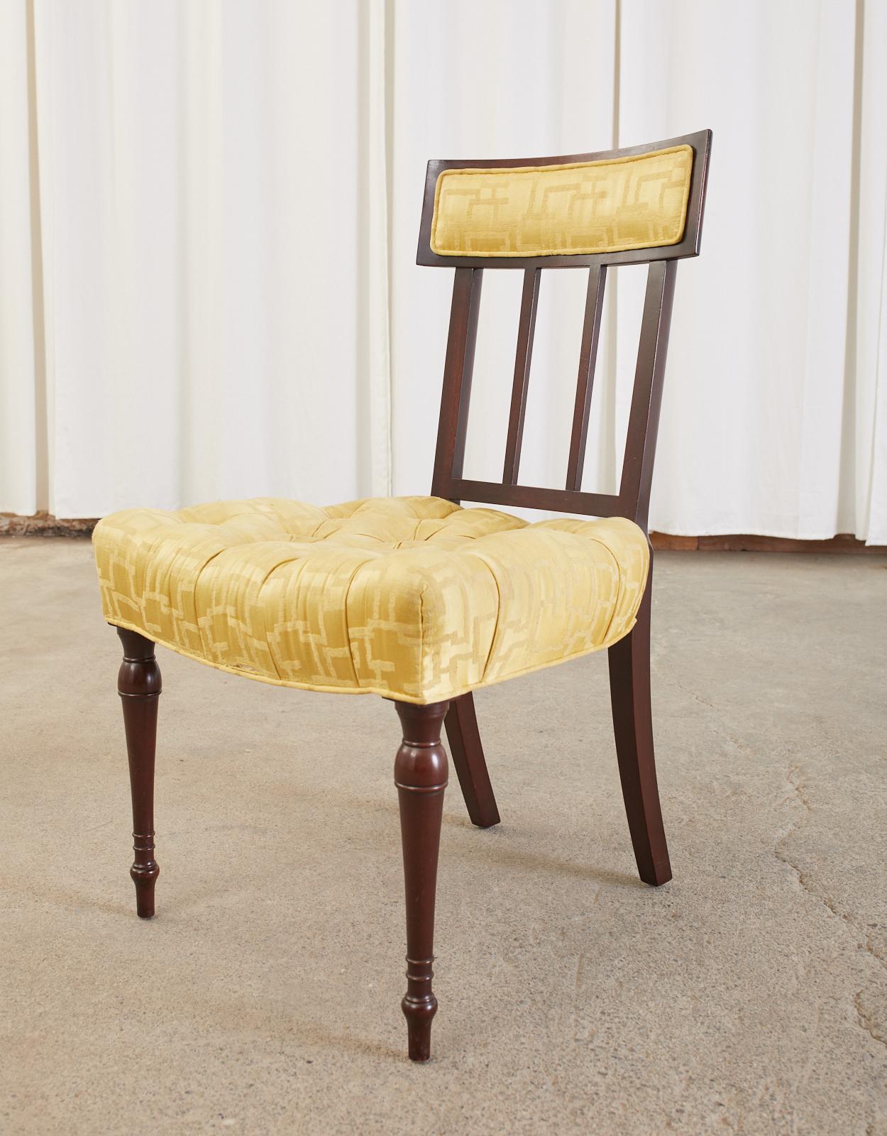 Extraordinary set of six English regency dining chairs crafted from mahogany. The chairs feature a rectangular tablet klismos style back rest conjoined to a generous curved seat. Upholstered with a thick seat having a golden geometric pattern