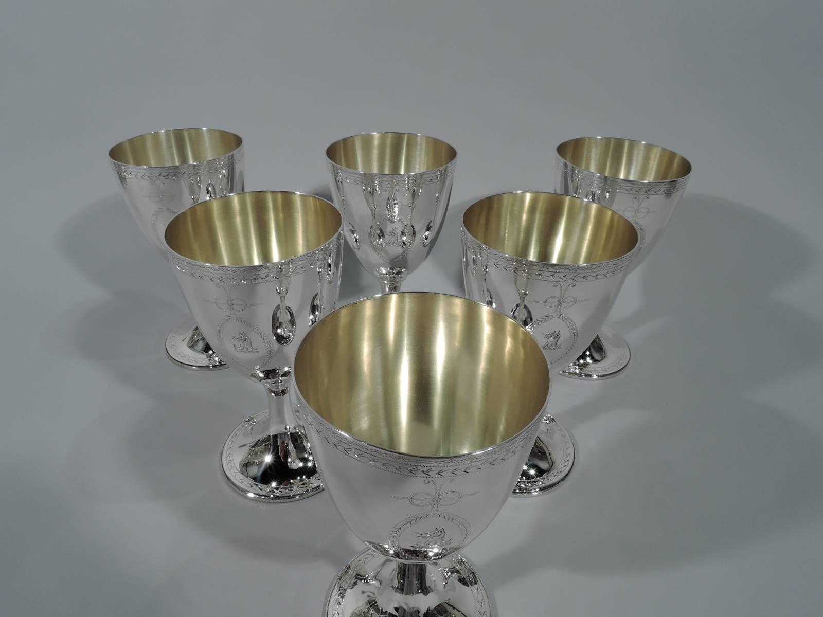 Set of six Regency neoclassical sterling silver goblets. Each: Ovoid bowl on cylindrical stem flowing into domed foot. Engraved ornament: wavy and zigzag rim bands and two bow-tied oval pendant frames (1 frame vacant; the other has armorial).
