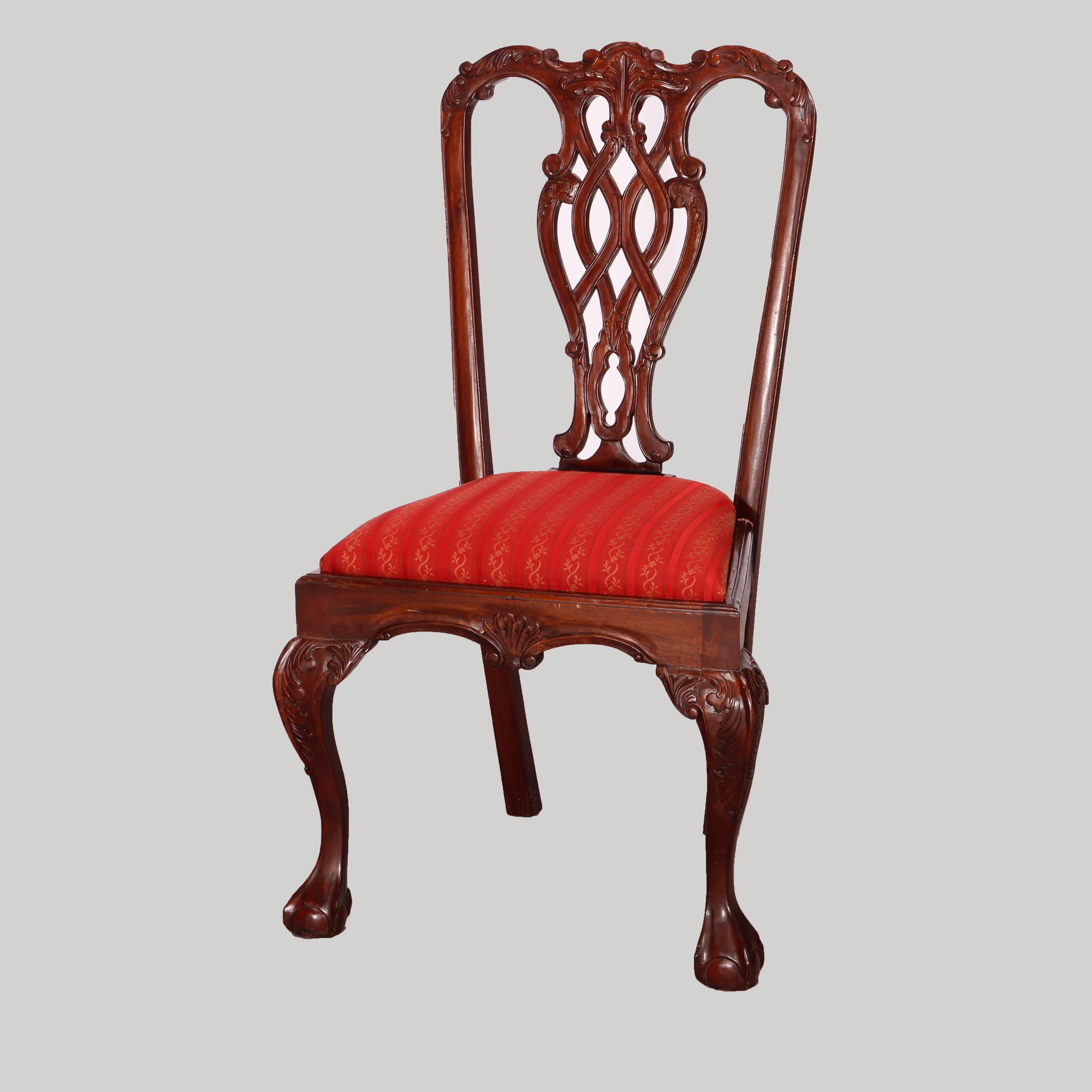 A set of six Federal or Chippendale style dining room chairs offer carved mahogany ribbon backs with foliate elements over upholstered seats and raised on cabriole legs having scrolled acanthus knees and terminating in claw and ball feet, 20th