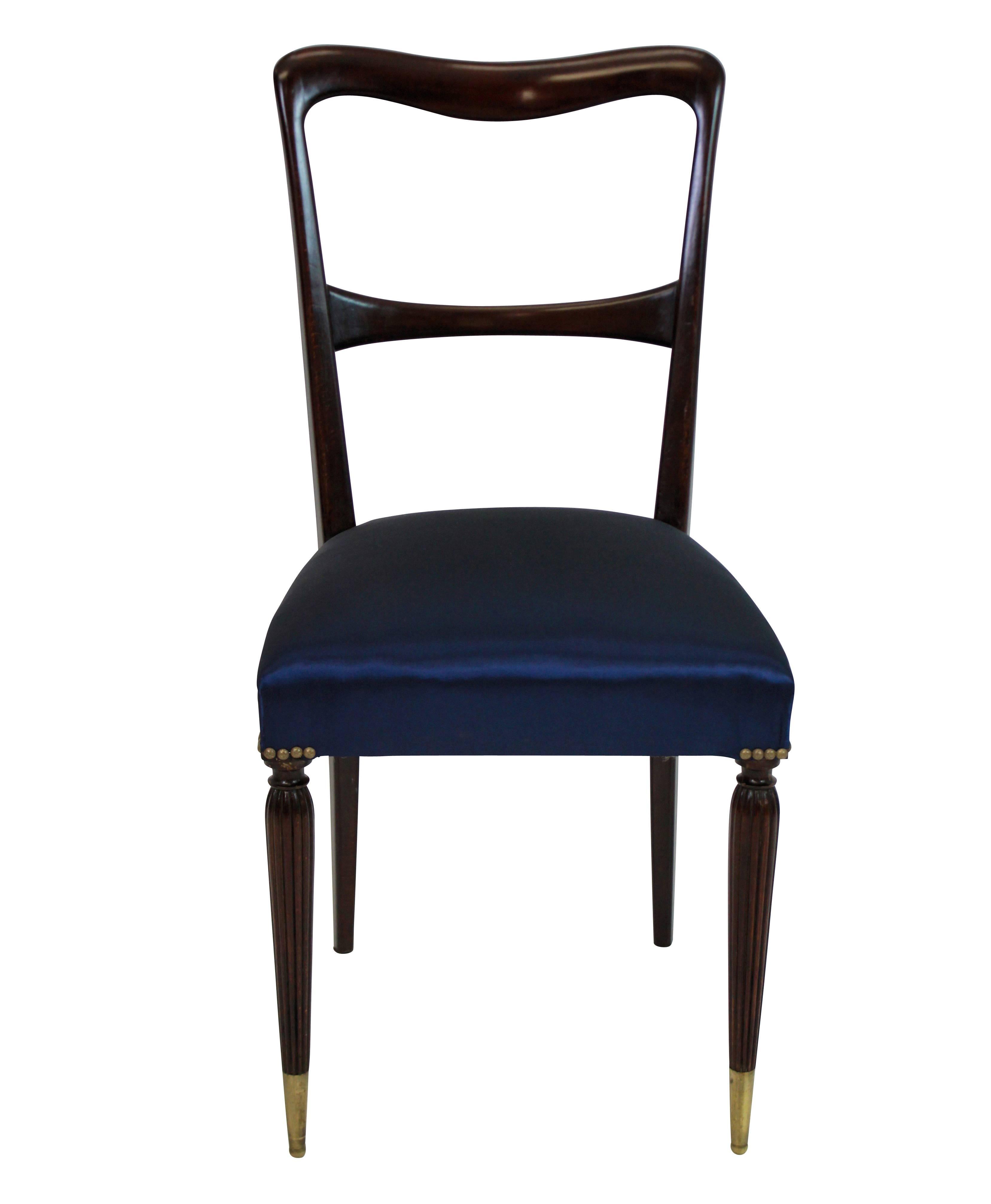 A set of six fine quality Italian midcentury dining chairs in stained beech, with sculptural backs, long brass sabot feet and newly upholstered in deep blue silk.
  
  