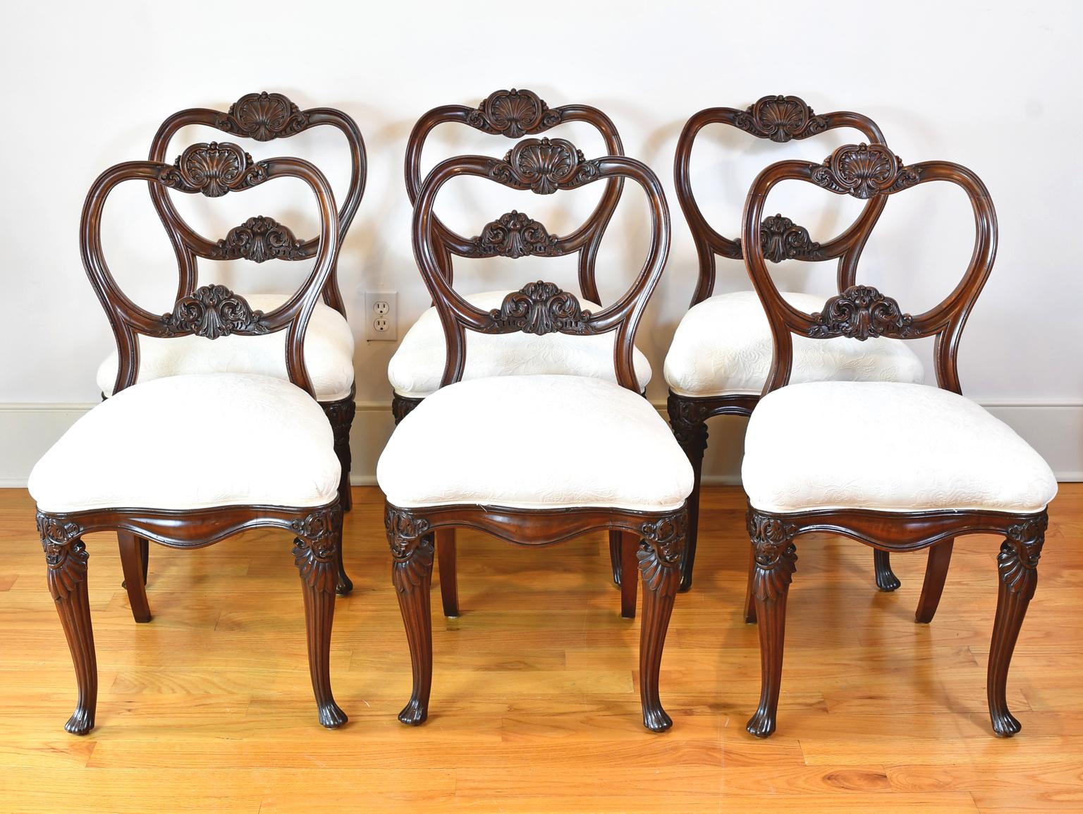A very lovely set of six dining chairs in dence West Indies mahogany of high quality with well-articulated carvings of scallop and acanthus on crest, rail, and knee. Carved frame of upholstered seat has a serpentine form on all four-side with front