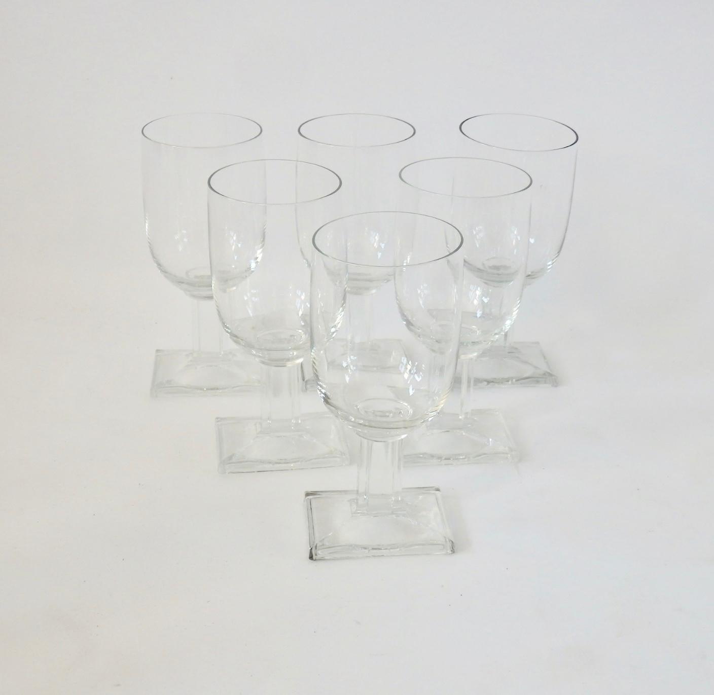 Six Art Deco wine glasses. Rectangular base supports round glass on fluted shaft. Base measures 2 7/8