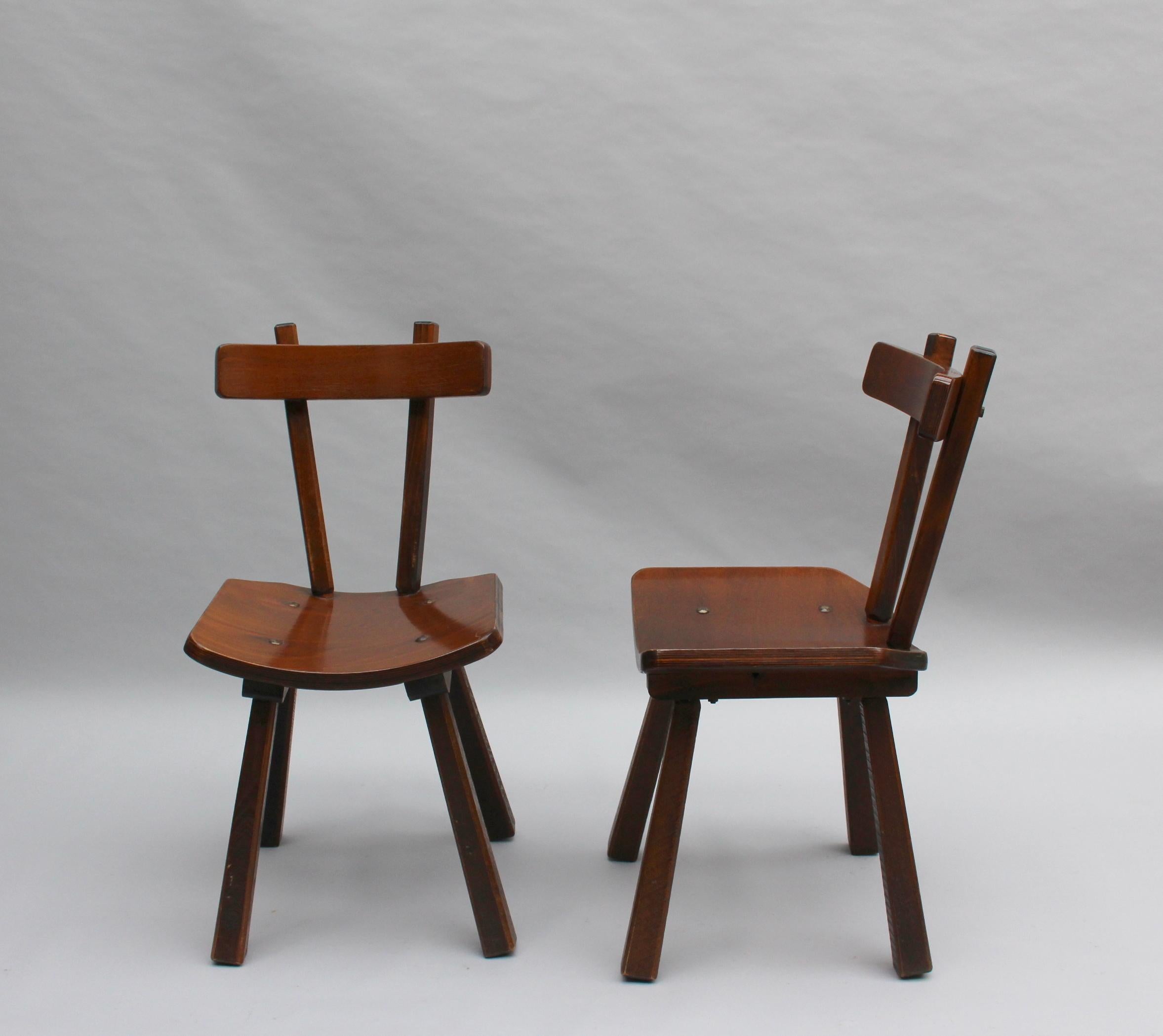A set of six French midcentury solid and laminated wood chairs.