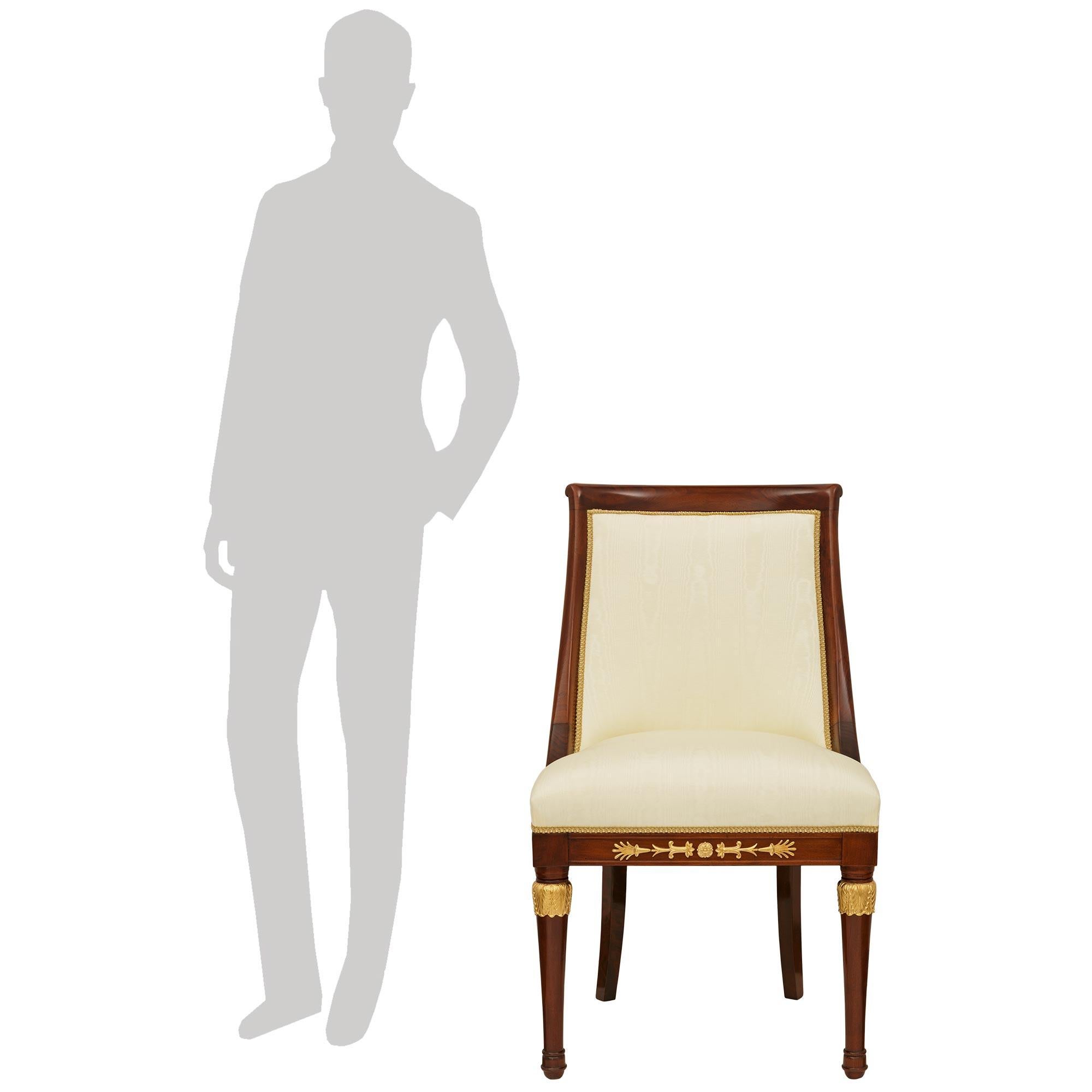 Un bel set di sei sedie da pranzo francesi del XIX secolo in mogano stile Impero e Ormolu. Questo meraviglioso set è sollevato da quattro gambe anteriori circolari e affusolate, mentre le gambe posteriori hanno una forma quadrata e affusolata. Le