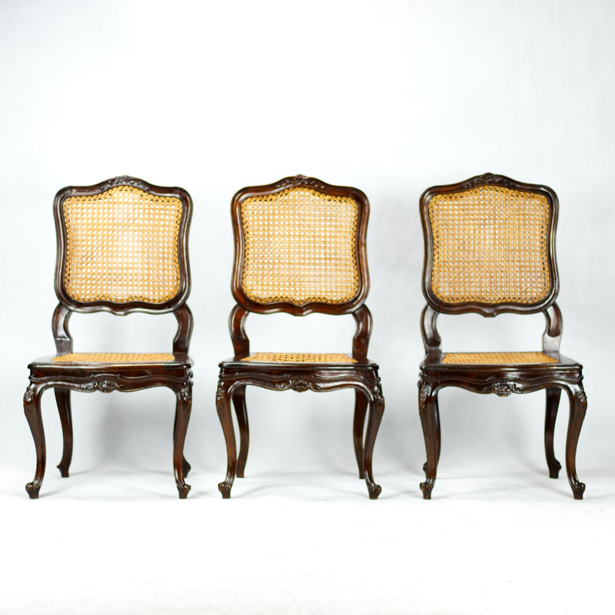 A set of six French hand carved dining chairs from the second half of the 19th century with cane seats and backrests.
Louis XV-style dining chairs in walnut style with well-articulated leaf carvings on the back and apron, with woven seat and back