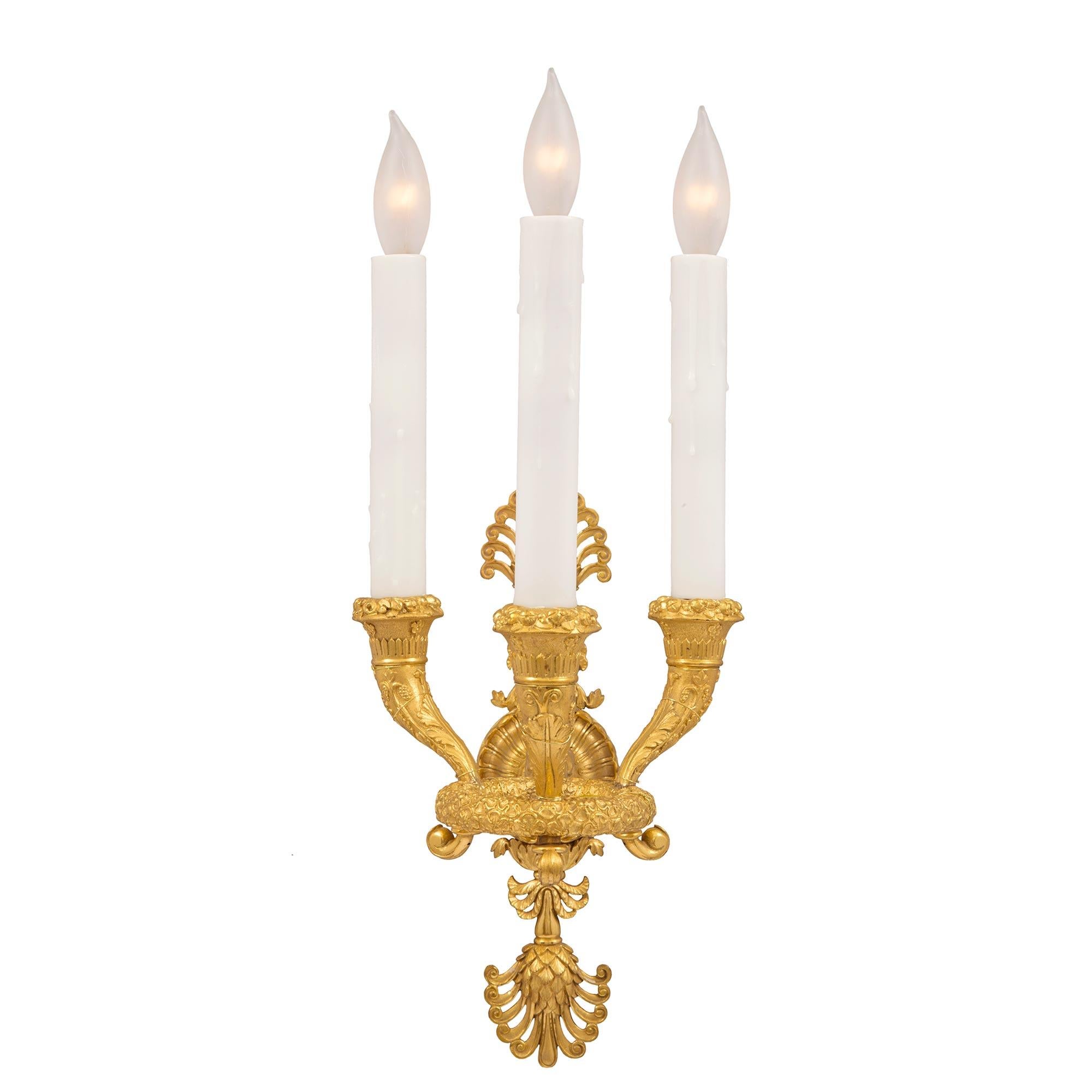 A stunning high quality complete set of six French 19th century Neo-Classical st. three arm ormolu sconces. Each sconce in centered by a striking pierced palmette backplate from where a most impressive scrolled swan's neck extends. The swan's neck