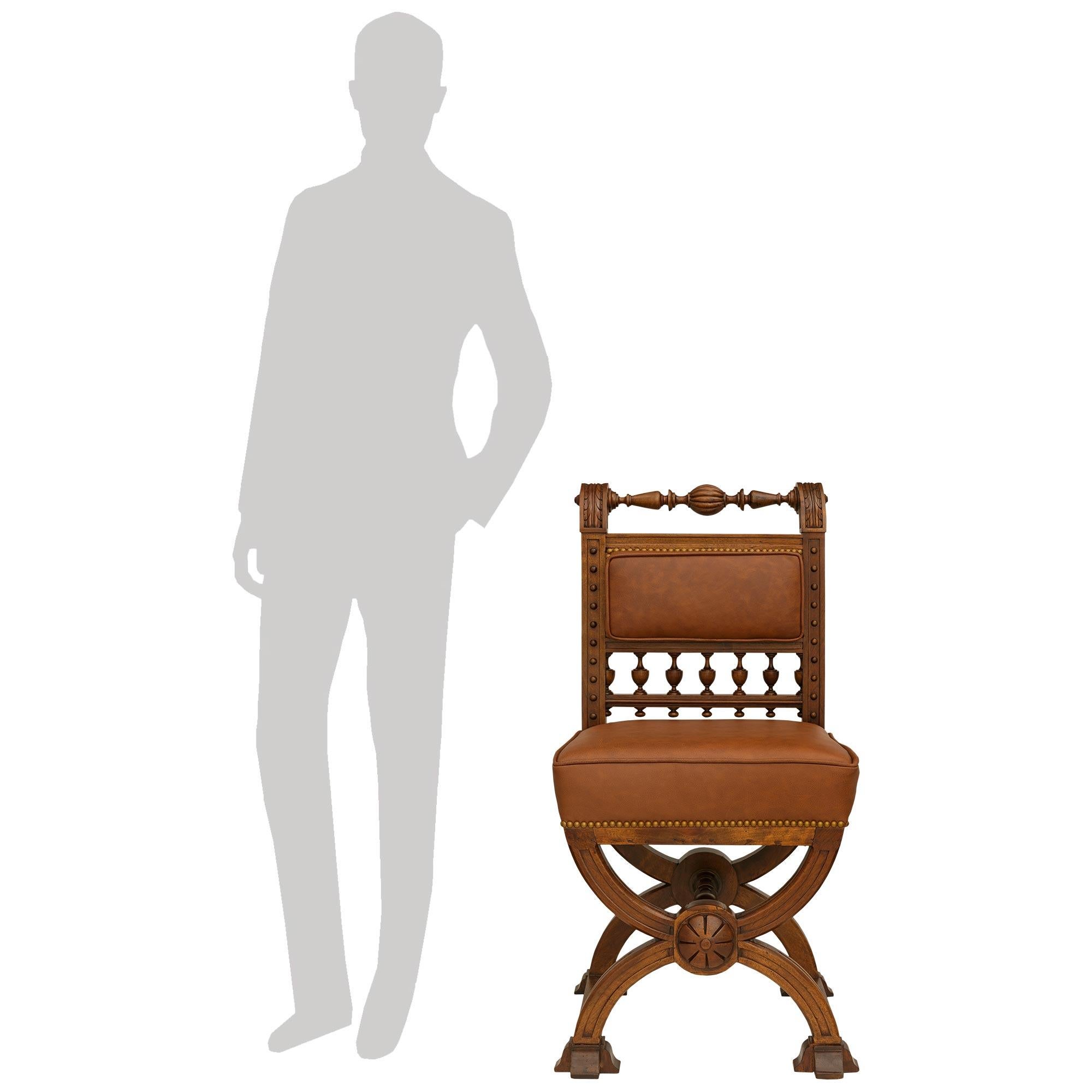 A handsome and high quality set of six French 19th century Renaissance st. Walnut and Leather dining chairs. Each wonderfully decorative chair is raised on four mottled block feet connected by flat stretchers at the bottom and double X designed