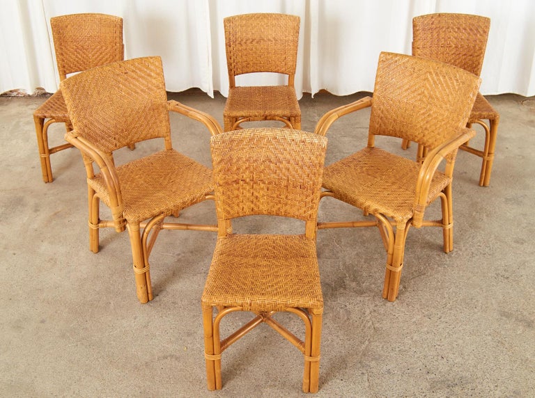 Organic modern set of six French rattan and wicker cane dining chairs made in the art deco style. The chairs feature rattan frames covered with woven wicker cane in classic art deco style geometric patterns. The set consists of two armchairs