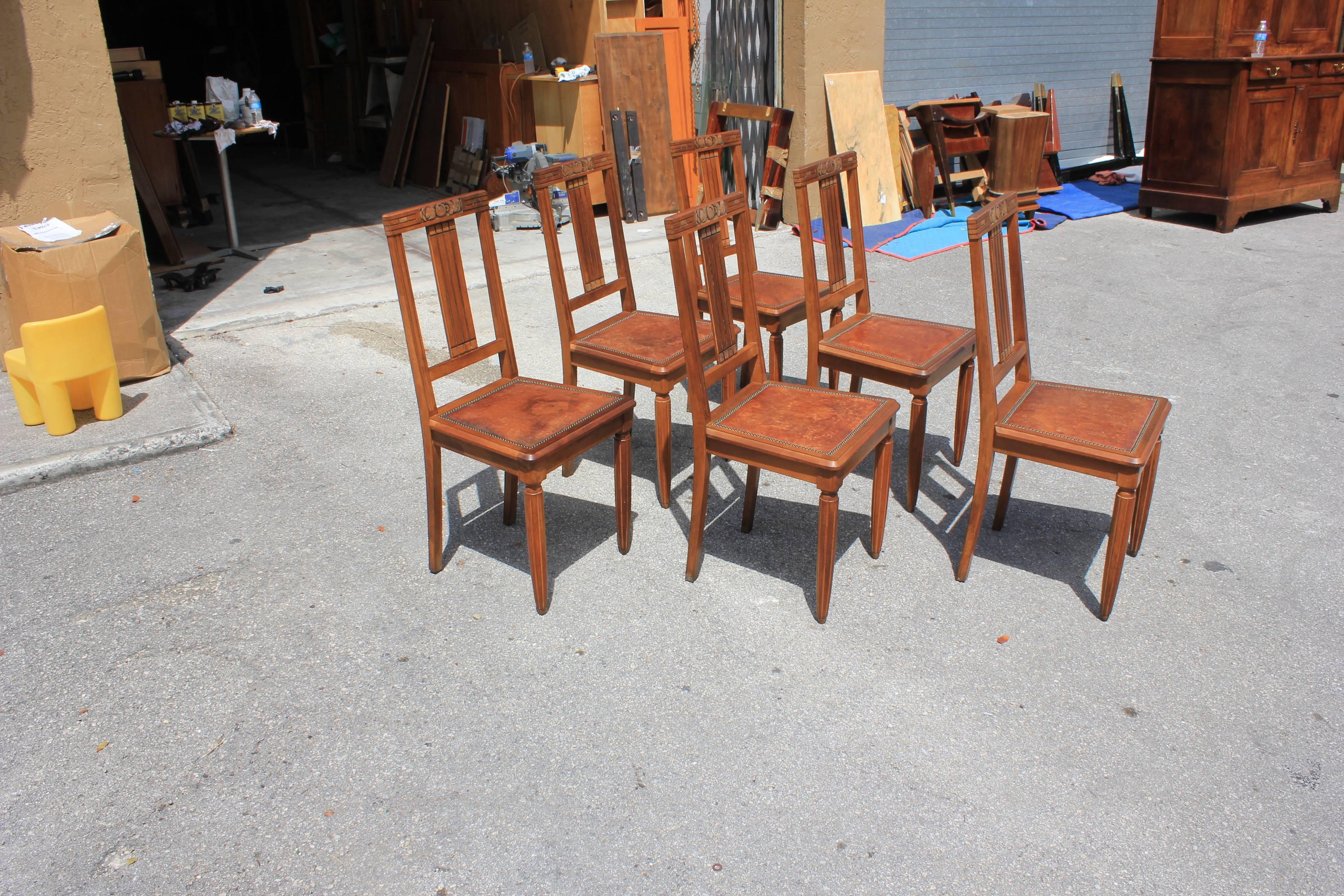 Set of six French Art Deco dining chairs solid walnut with leather seat, the chair frames are in excellent condition. The leather seat are in very good condition for all six dining chairs, the color of the dining chairs are beautiful, circa 1940s.