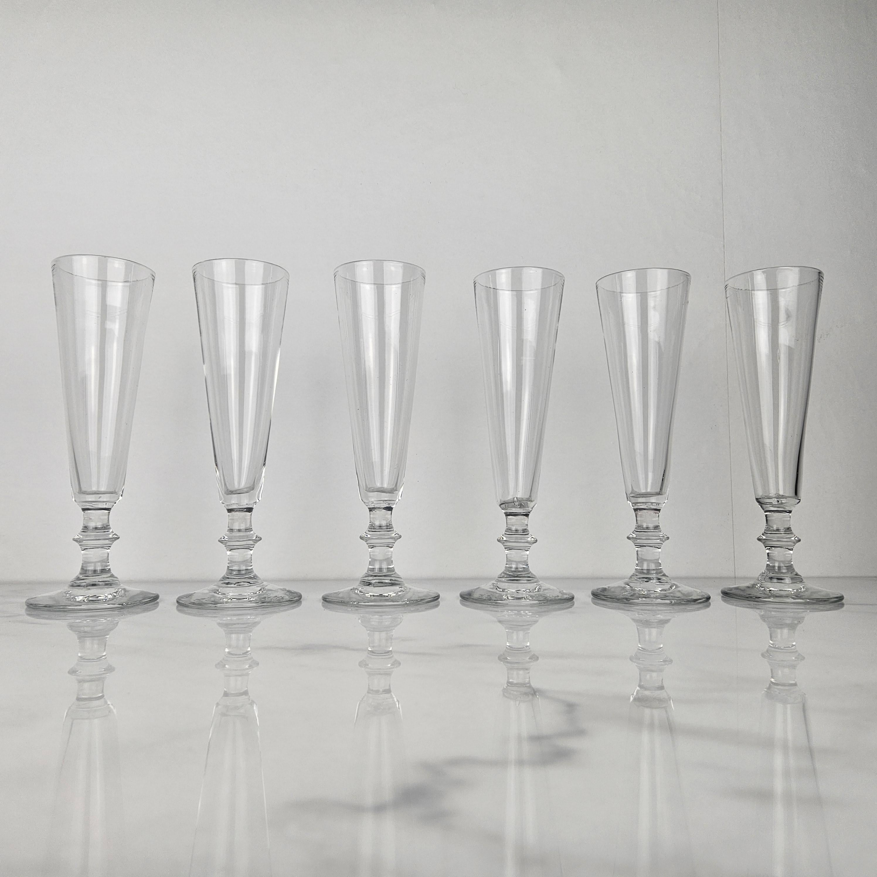 A beautiful set of six handmade French Champagne flutes in glass, fabricated around 1870.  

These antique glasses are mouth-blown. 

Please take notice of the very nice details and the elegant design.
Meticulously handcrafted, these exquisite