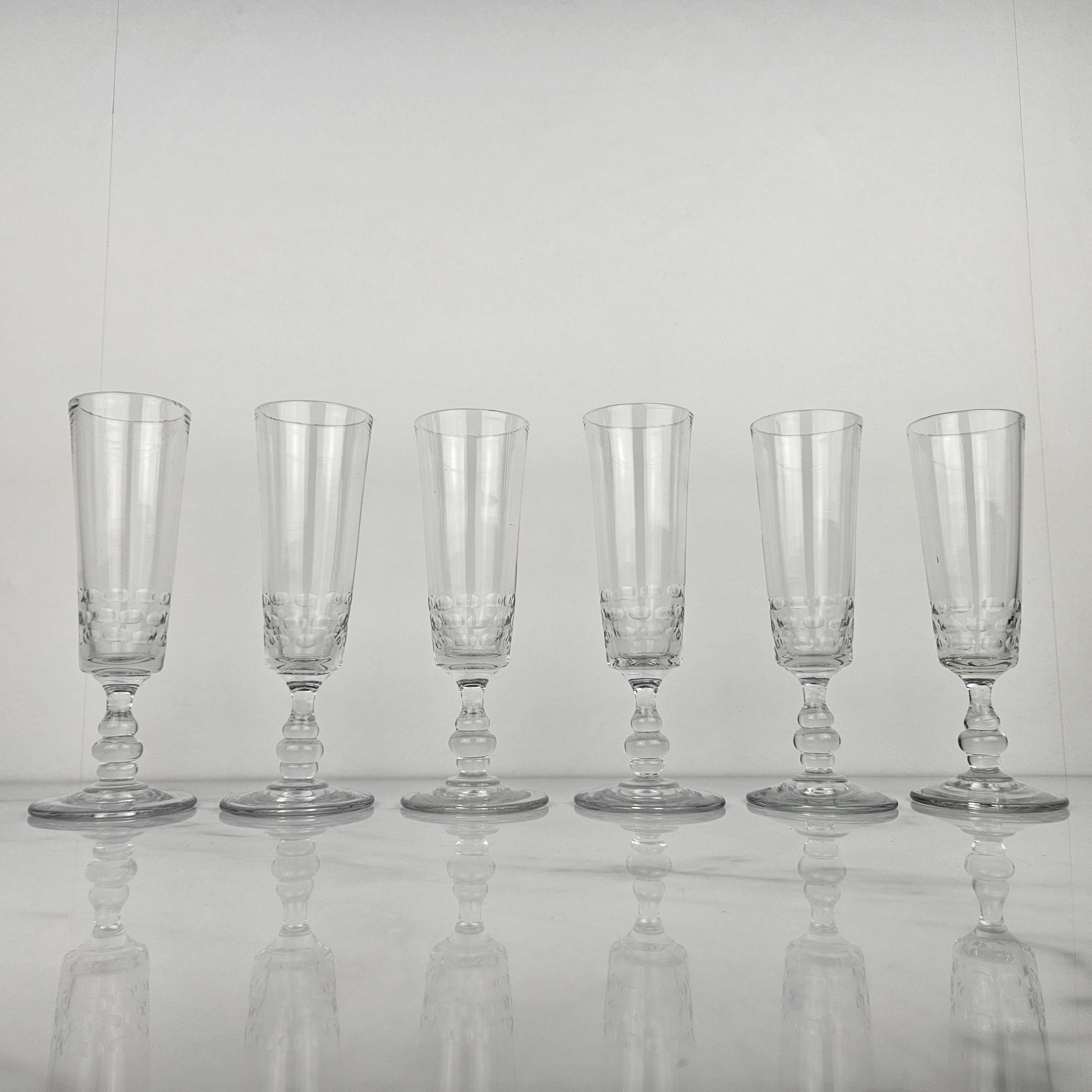 Un bel ensemble de six flûtes à champagne françaises en verre, fabriquées à la main vers 1880.  

Ces verres anciens sont soufflés à la bouche. 

Remarquez les très beaux détails et le design élégant.
Méticuleusement fabriquées à la main, ces pièces