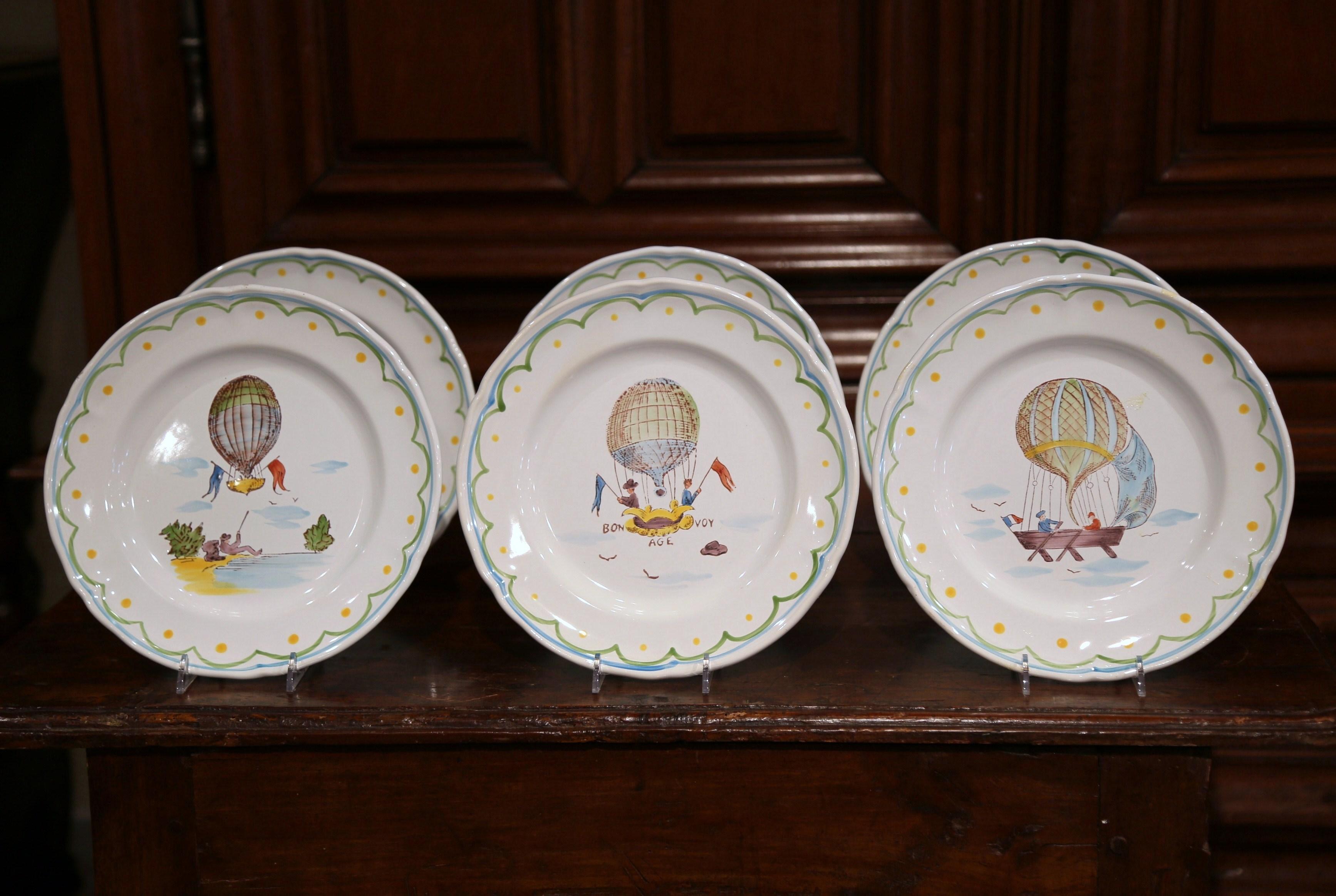 Decorate a kitchen wall or fill up a decorative hutch with this beautiful set of hand painted, ceramic plates. Crafted circa 2000 in Pornic, France, each hand painted plate is different and features individual hot air balloon scenes and accompanying