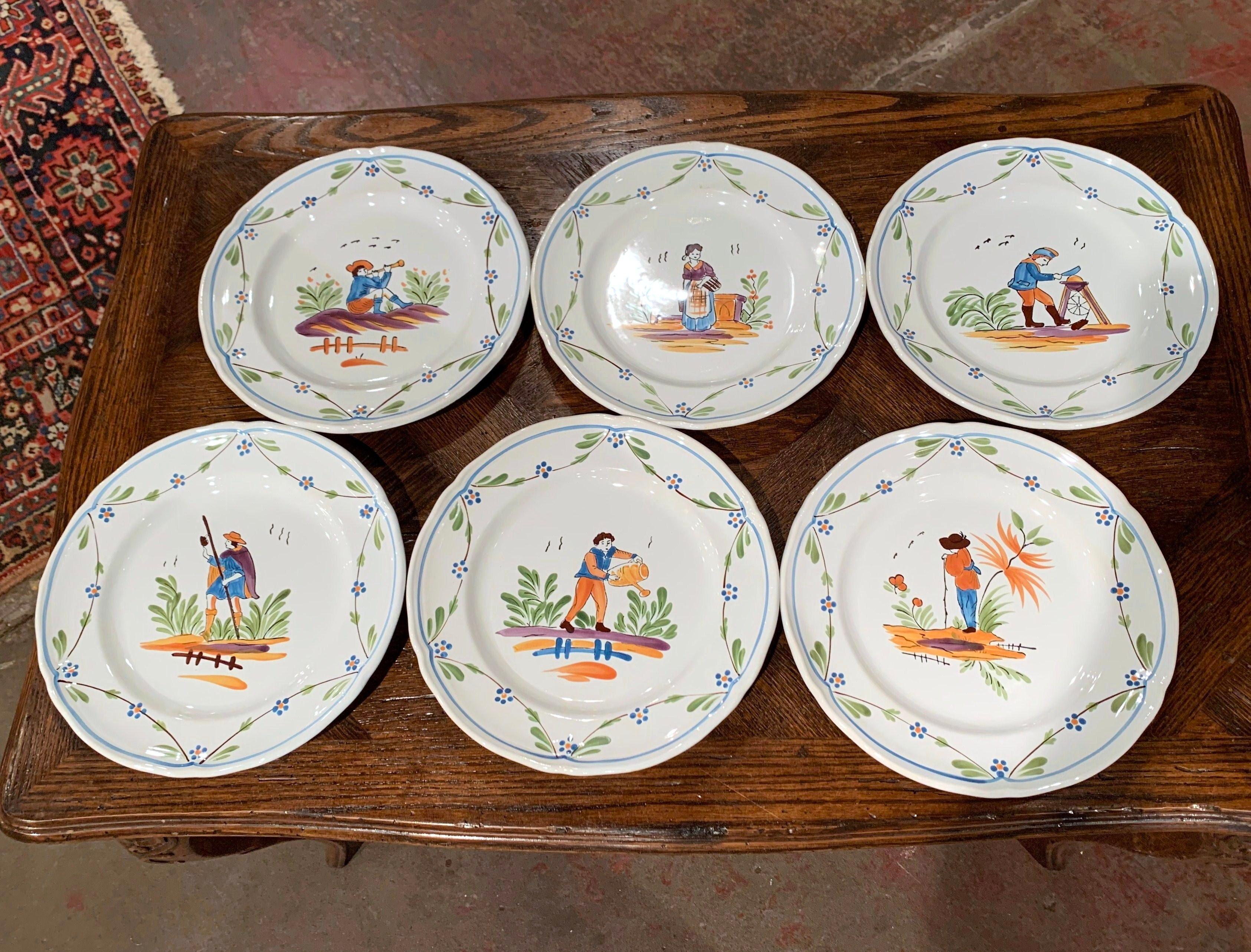Decorate a kitchen wall or fill up a decorative hutch with this elegant set of hand painted, ceramic plates. Crafted circa 2000 in Pornic, France, each colorful plate is hand painted with floral and leaf decor, and depicts Breton people at work in