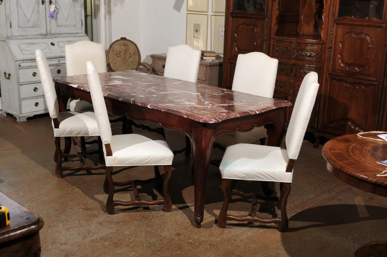 A set of six French walnut Louis XIII style 'os de mouton' dining room side chairs from the 19th century, with cotton upholstery. Born in France during the politically dynamic 19th century, each of this set of six dining chairs features a slanted
