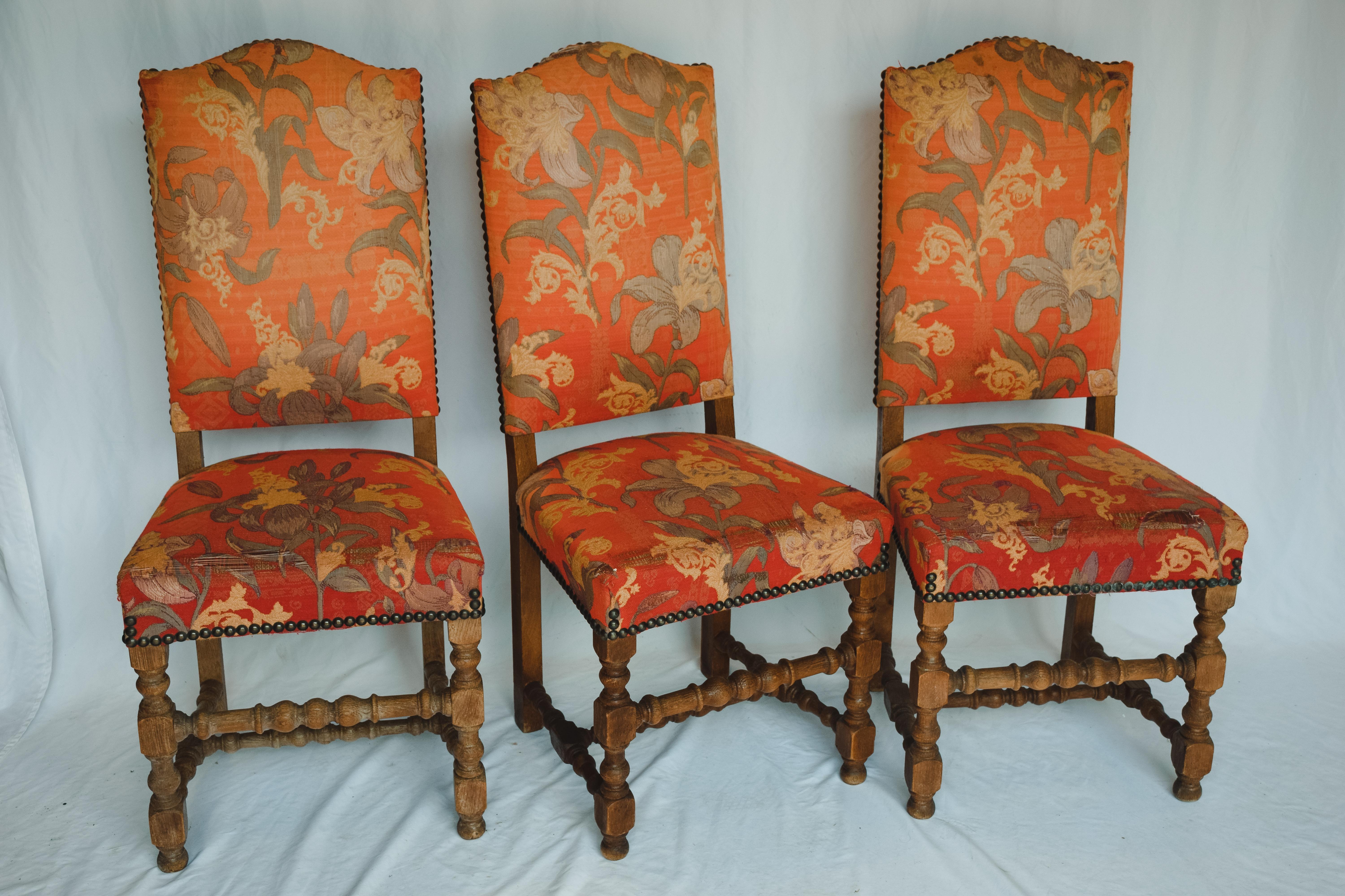 Authentic French country look. These Classic side chairs are upholstered with their original red floral motif upholstery, further embellished with decorative brass nail heads around the frame. The traditional dining chairs are in excellent condition
