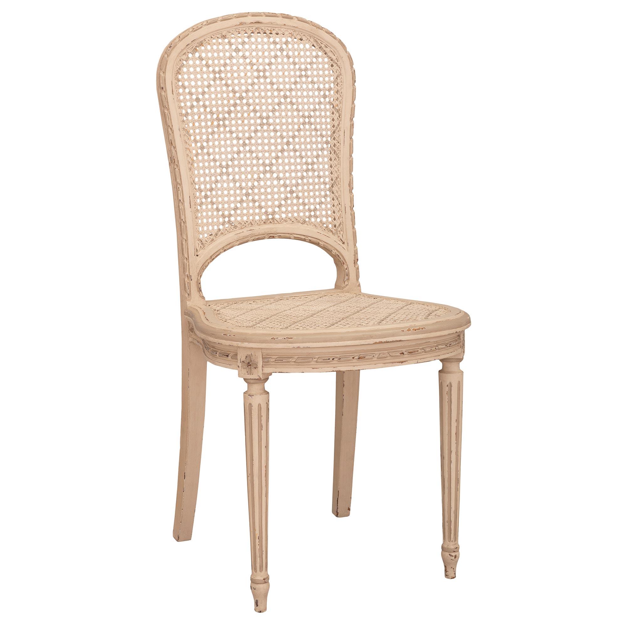Ein charmanter und eleganter Satz von sechs französischen Esszimmerstühlen aus patiniertem Holz im Stil Louis XVI des 19. Jeder Stuhl steht auf feinen, kreisförmig verjüngten, kannelierten Beinen mit schönen, topieförmigen Füßen. Über jedem Bein