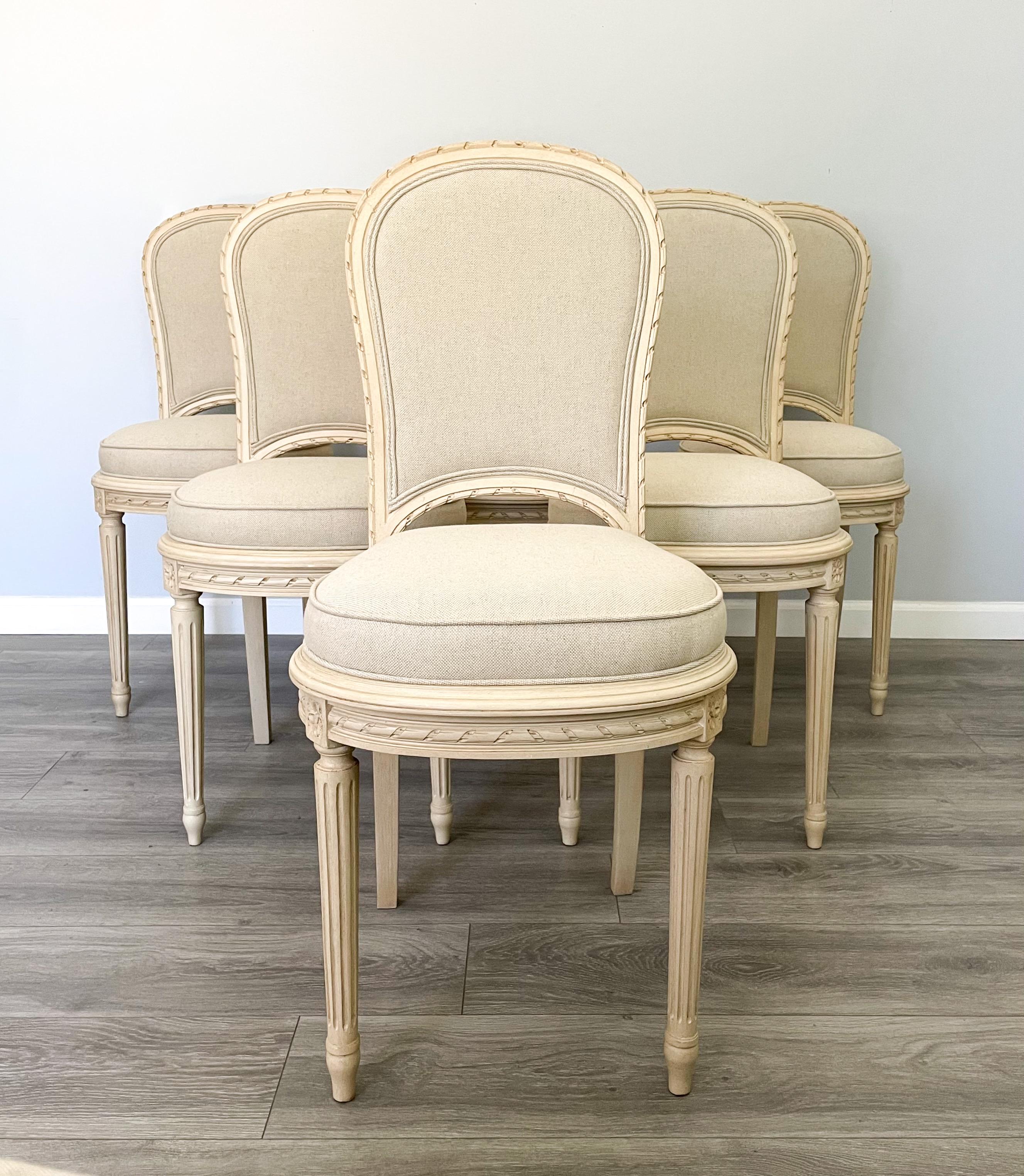 Beautiful, set of 6 French 1920s dining chairs by Laurenceau, Paris. 

Each chair consists of a delicately carved wood frame styled in the Louis XVI style. 

The chairs have been newly painted in a vintage crème color with a hand-applied antique