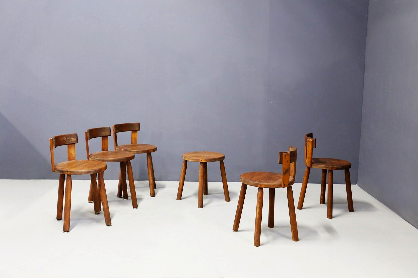Set consisting of six chairs chairs and a French stool made entirely of wood of the 50 years. The chairs have an unusual line in fact are in the taste of Charlotte Perriand. The feet are made of cylindrical blocks of wood, while the backrest is made