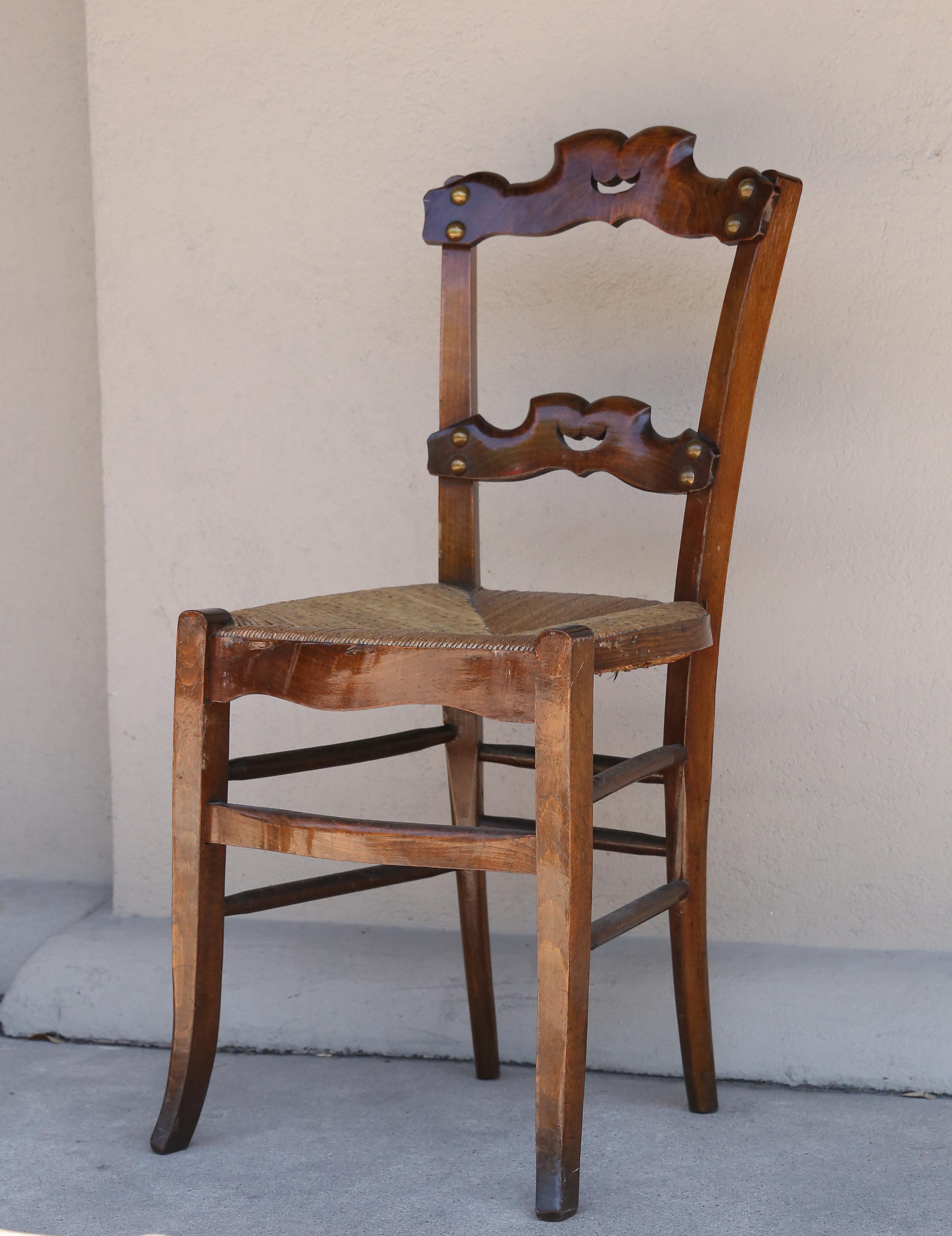 Set of six rush-seat dining chairs sourced in Belgium. These chairs are in wonderful condition, considering their age. The rush seats are all in good shape and the finish of each is very good. The ladder-back style has a more ornate shape than the