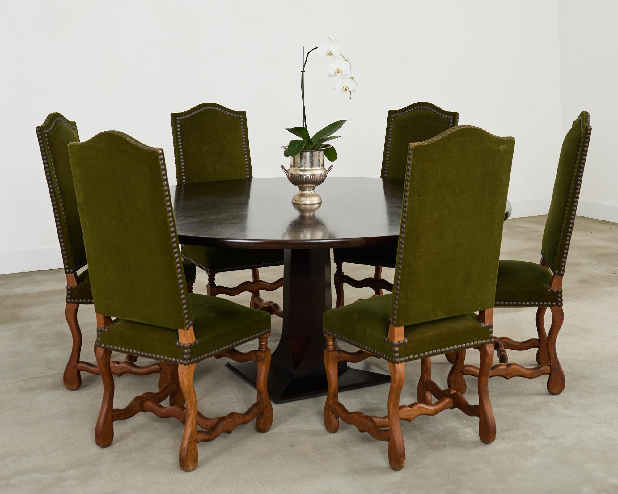 Gorgeous set of six French Os de Mouton baroque style dining chairs crafted from oak. The stylish chairs feature a moss green mohair velvet upholstery bordered by patinated brass tack nail heads. The large oak frames have a humped crest and classic