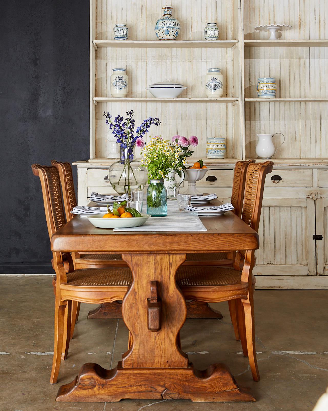 Distinctive set of six French provincial dining chairs featuring hand-caned seats and backs. Beautifully carved mahogany frames with a subtle shield shaped back conjoined to a Classic D-shaped seat with a bowed front and decorative serpentine apron.