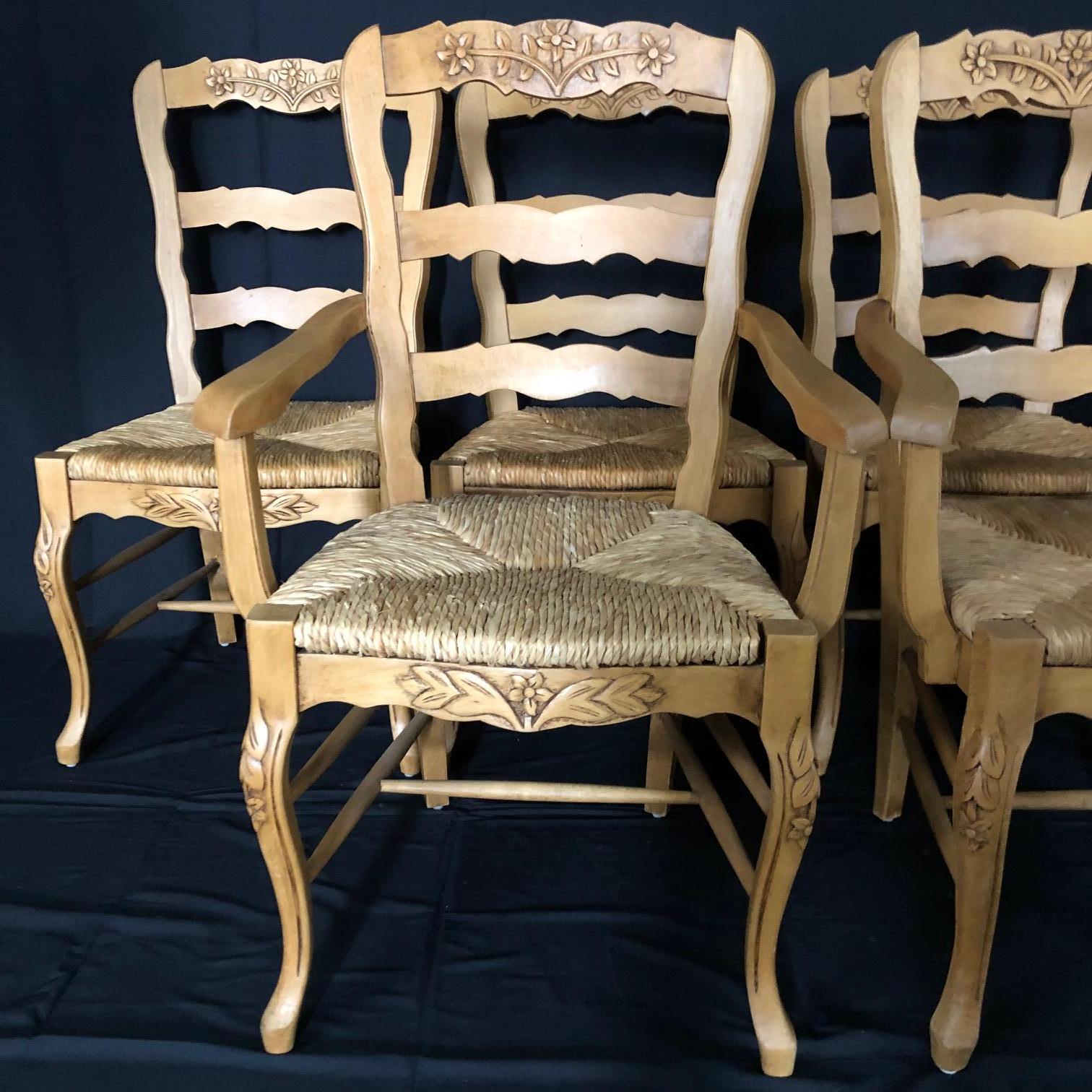 Immaculate set of six 20th century Provincial walnut chairs with lovely carving on the ladderback tops, on the apron, and on the elegant cabriole legs. Two armchairs and four side chairs. The rush seats are all in excellent condition and the chairs