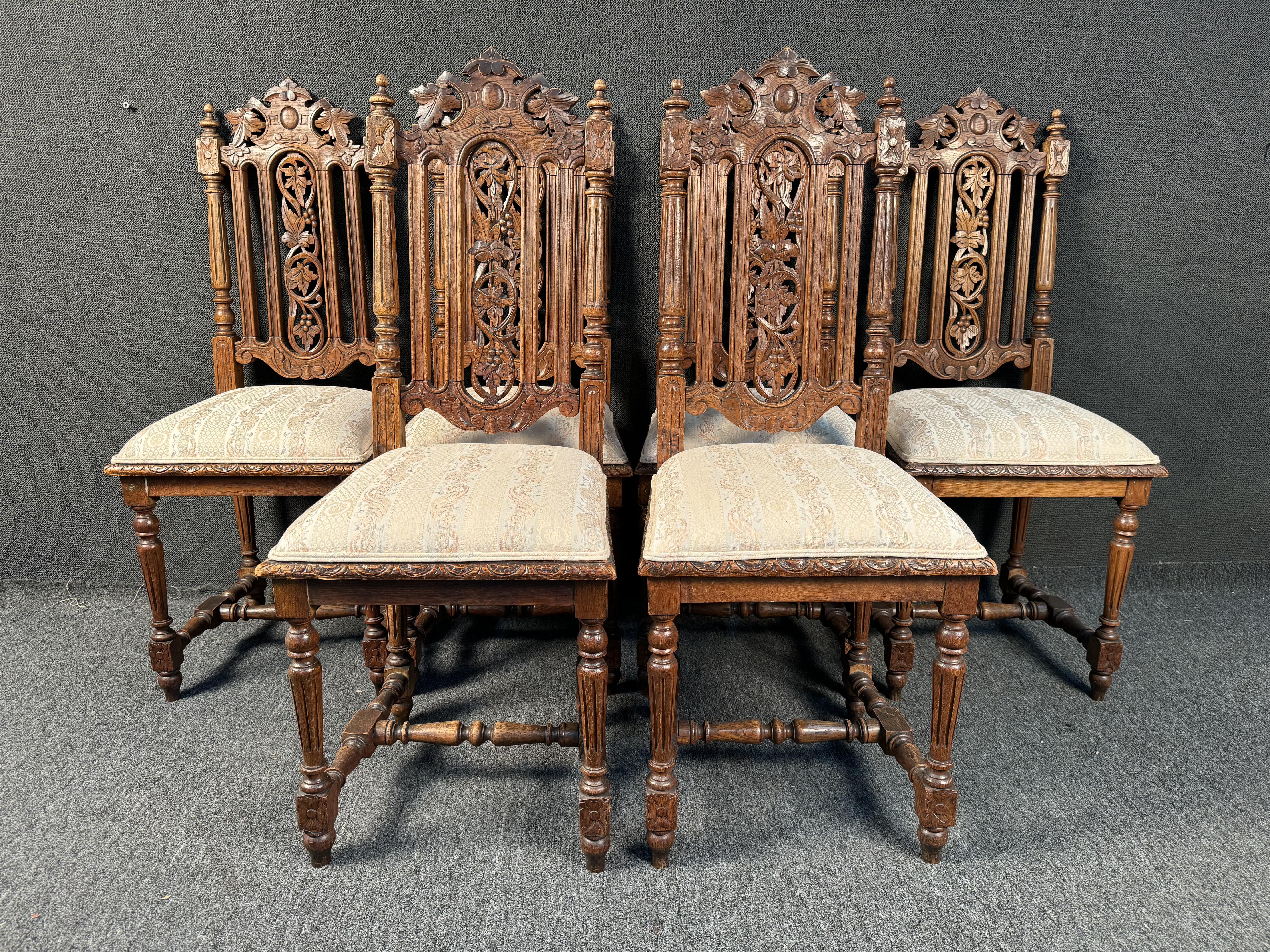 Beautiful set of Six French Renaissance Dining Chairs chairs in oak wood from the end of the 19th century. These chairs rest on four fluted legs connected together by a turned wooden spacer. The backrests are high, open and hand sculpted. On each